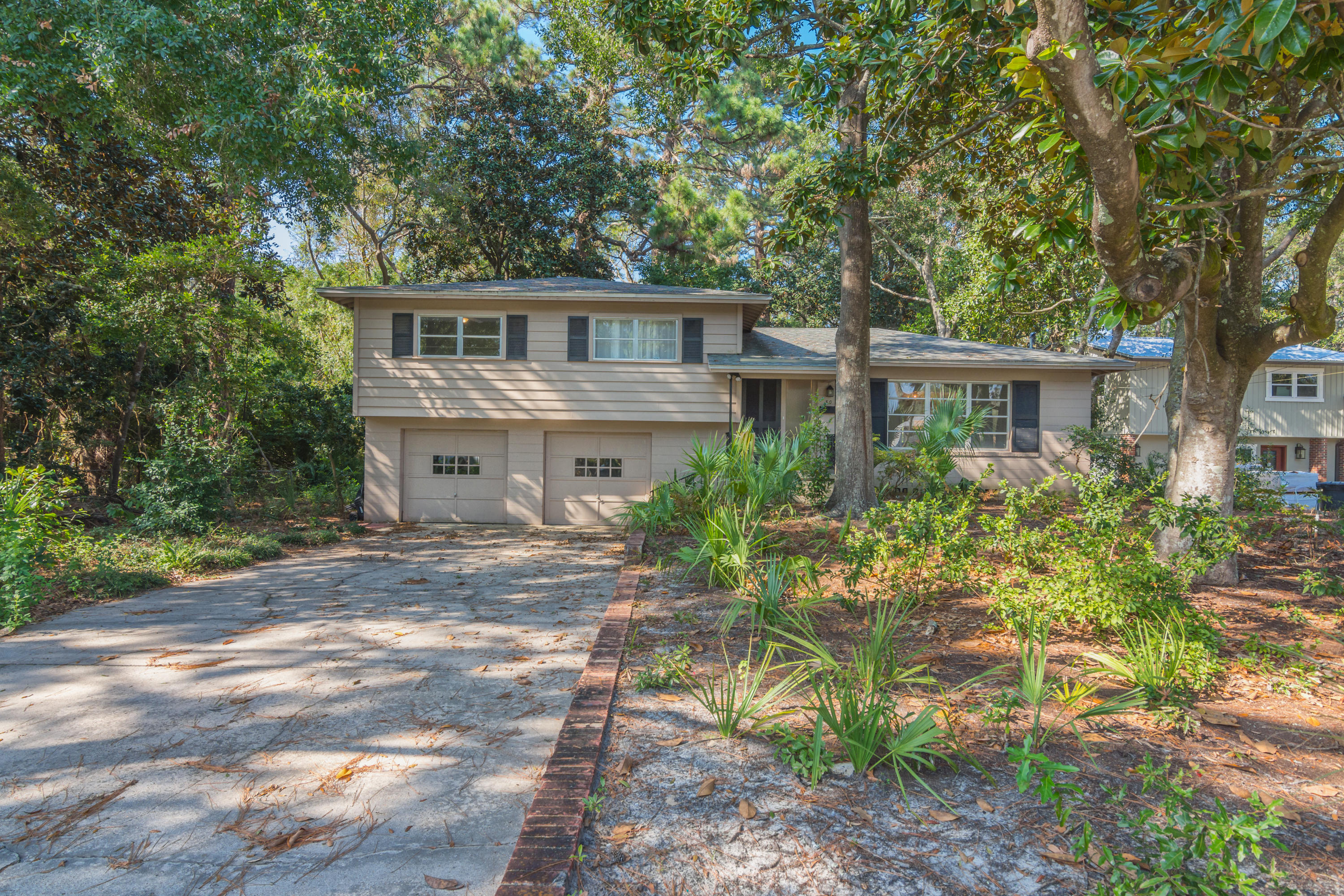 Unique home in the trees! This charming concrete block home sits back on a wood lot in the heart of Elliott Point and backs up to the neighborhood park. This home has been in the same family since it was built. In fact, it was built by the same family that still owns it. He developed many of the homes in the southeast corner of Elliott Point in the 1950's & 1960's. The family breathed new life into this beautiful home through updates and renovations in recent years and have used it as a second home until now. The original solid wood floors were re-finished in a beautiful walnut stain. The original brass hardware and handmade louvered doors and shutters are still in use today. The back room is without a doubt the highlight of the home---floor to ceiling glass windows and the original