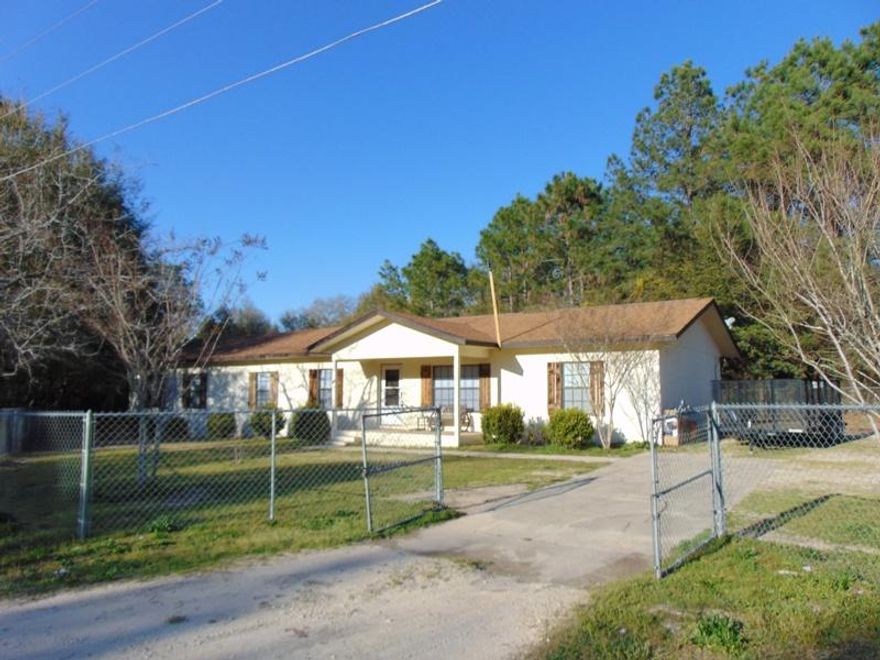 Great location South of I-10 on this 4-5 bedroom, 3 bath home with two master bedrooms! This spacious 2050 SF home on apx. 1 acre is neat as a pin and just waiting for a new family! Exterior features include covered front porch, 16x24 back deck, patio, shed/workshop with power, chain link fencing around entire perimeter. Interior features include 13x12 master at one end and 23x25 master at other (both have walk-in closets and full bath). Large master could also be used as game room, family room or would be great for extended family. 2 of the additional 3 rooms have windows, but no closets (could be used as bedrooms or separate offices). Entire home has tile floors, with the exception of 2 bedrooms, which are carpeted. So many possibilities with this home. Schedule your showing today!