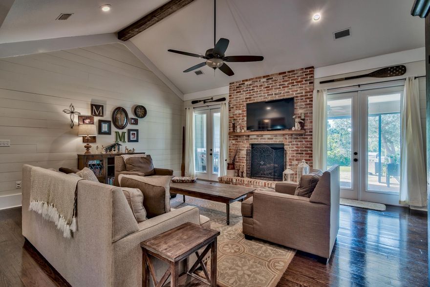 This charming waterfront home with dock is being offered on two lots totaling 1.84 acres! Perfectly positioned and masterfully planned, this 3 bedroom with separate office/bonus room is sure to please the most discriminating buyer. Upon entering the foyer you will be greeted with shiplap walls and hardwood flooring, which will carry over into the open living area featuring a vaulted ceiling accented with a beam of cypress, and fireplace finished with reclaimed brick that spans floor to ceiling. The open concept plan will lead you into a finely appointed kitchen, featuring custom Knotty Alder wood cabinetry, gas stove-top with an industrial range, brick backsplash and granite countertops, finished with a hammered-copper farmhouse sink. Once inside the master bedroom you will notice