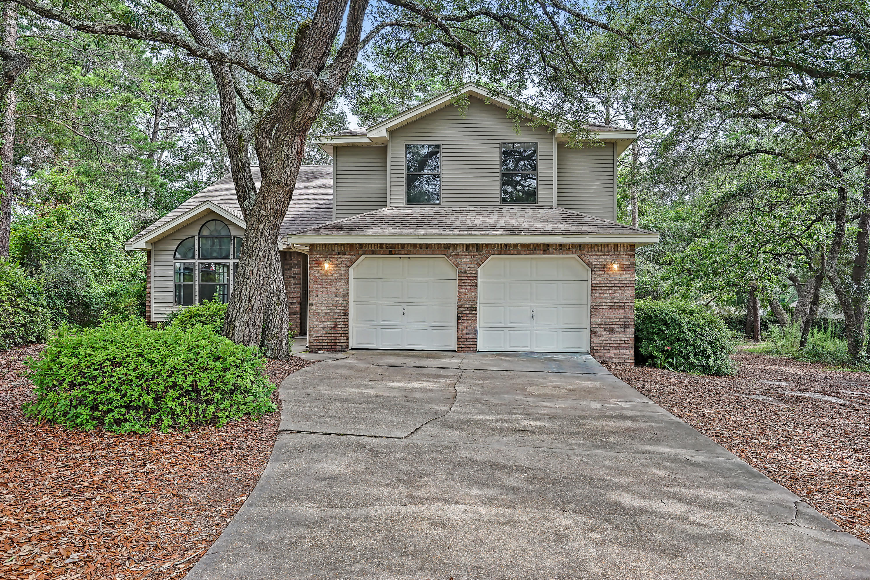 A great location and lovely design with NEW carpet, NEW Luxury Vinyl Plank flooring, FRESH paint, ample storage, a second family room, indoor laundry, and a two car garage. The kitchen accesses both the formal dining room and a cozy family room with a fireplace and sliding glass doors that lead to an all-natural and low maintenance yard with a large deck and bench seating to enjoy all year long. The other spacious family room has a beautiful window seat below arched windows looking up to vaulted ceilings. An elegant quarter-turn staircase rises to four bedrooms and an open hallway with baluster railing that overlooks the front of the home. The master bedroom greets with double doors and has a nice view of the treelined property. The en-suite master bath has double sinks and walk in closet.