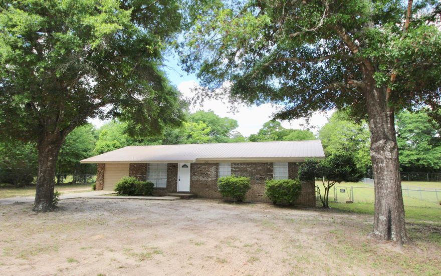 Neat and clean - and sits on a 1/2 acre lot inside the city limits of DeFuniak Springs. Tile floors throughout with kitchen and dining area combined. New paint throughout. The kitchen window overlooks the large, fenced in back yard. There is a step down den which could be used as or converted to a 4th bedroom if needed. The space is well allocated with good sized rooms throughout. Also you'll find a small sturdy building which would be ideal for storage, a small home-based business or hobby, playhouse, etc. Just put a window a/c unit in and you're in business! Metal roof is appx 3 years new and you'll remain cool in the summer months with beautiful oak trees for shade. Come take a look before someone else snatches this cute home up! Qualifies for all types of financing.