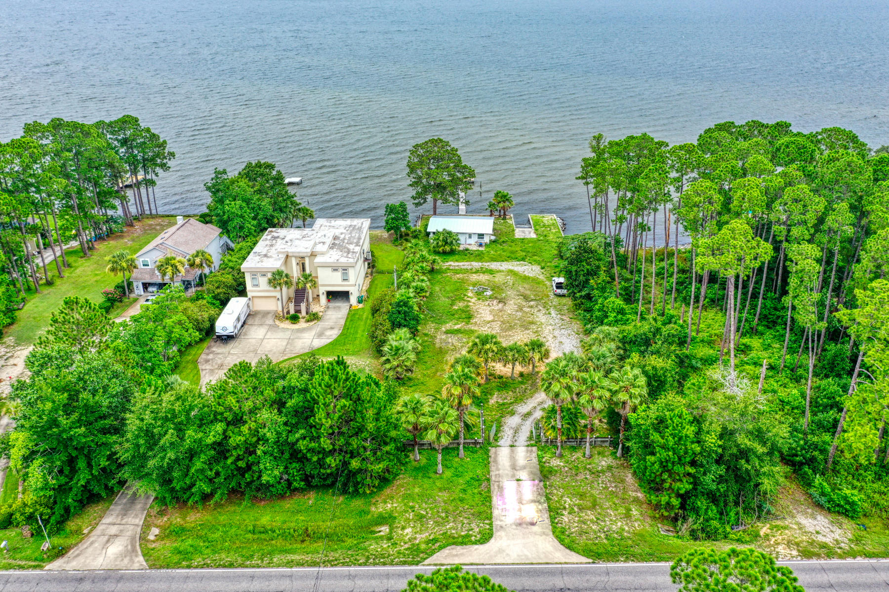 AS IS. THIS WILL NOT QUALIFY FOR A SINGLE FAMILY RESIDENCE LOAN. Amazing opportunity to build your dream home on Navarre's premiere East Bay. Relax and watch incredible sunsets and sunrises. You will be sure to catch a glimpse of frolicking dolphins from your lot. Wonder at the eagles, ospreys, and herons soaring through your quintessential Florida landscaped property. Launch your boat for a day on the water from the custom built boat launch with seawall already in place. Shell of Fish camp remains. Dock sustained damage in Hurricane Sally but piling still in place. Both conveyed AS IS.