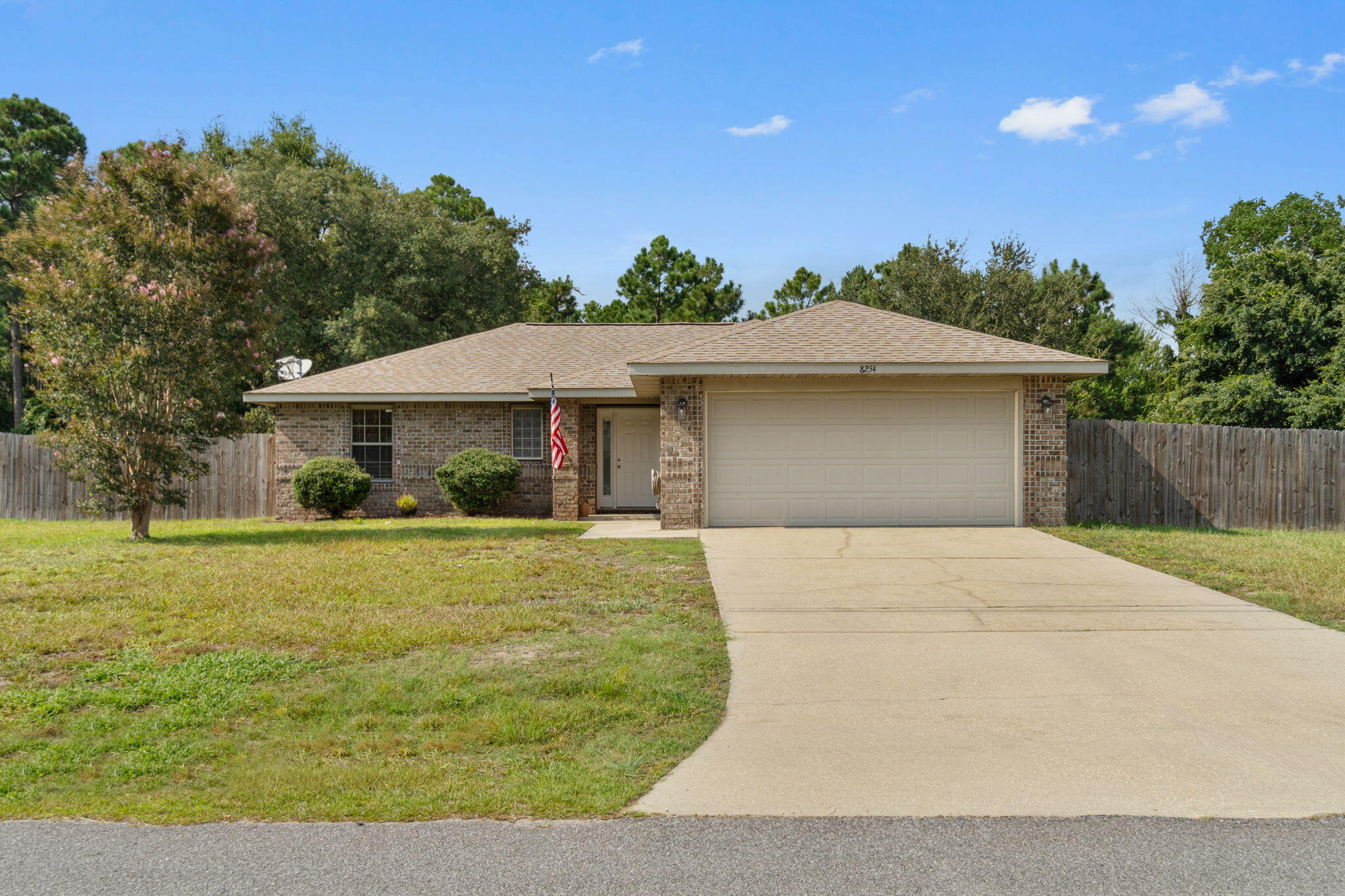 Picturesque, fresh bloom landscaping, move in ready brick home in Navarre has just hit the market! Sitting upon its half acre completely fenced and private grassy yard, quaint and timeless entryway greets visitors with ease. Upon walking in you'll be entering the foyer, giving way to vaulted ceilings in the great room. Being a vastly open floor plan, you'll have access to your granite counter and stainless kitchen, in home laundry, guest bedrooms as well as master bedroom. The bedrooms have all been outfitted with brand new plush carpet, with the master being adjoined by a large ensuite. The master bath is also featuring granite counters. Built in the modern times of 2010, a 1 year old oversized HVAC unit as of 2022, this home will be a delight for years to come.