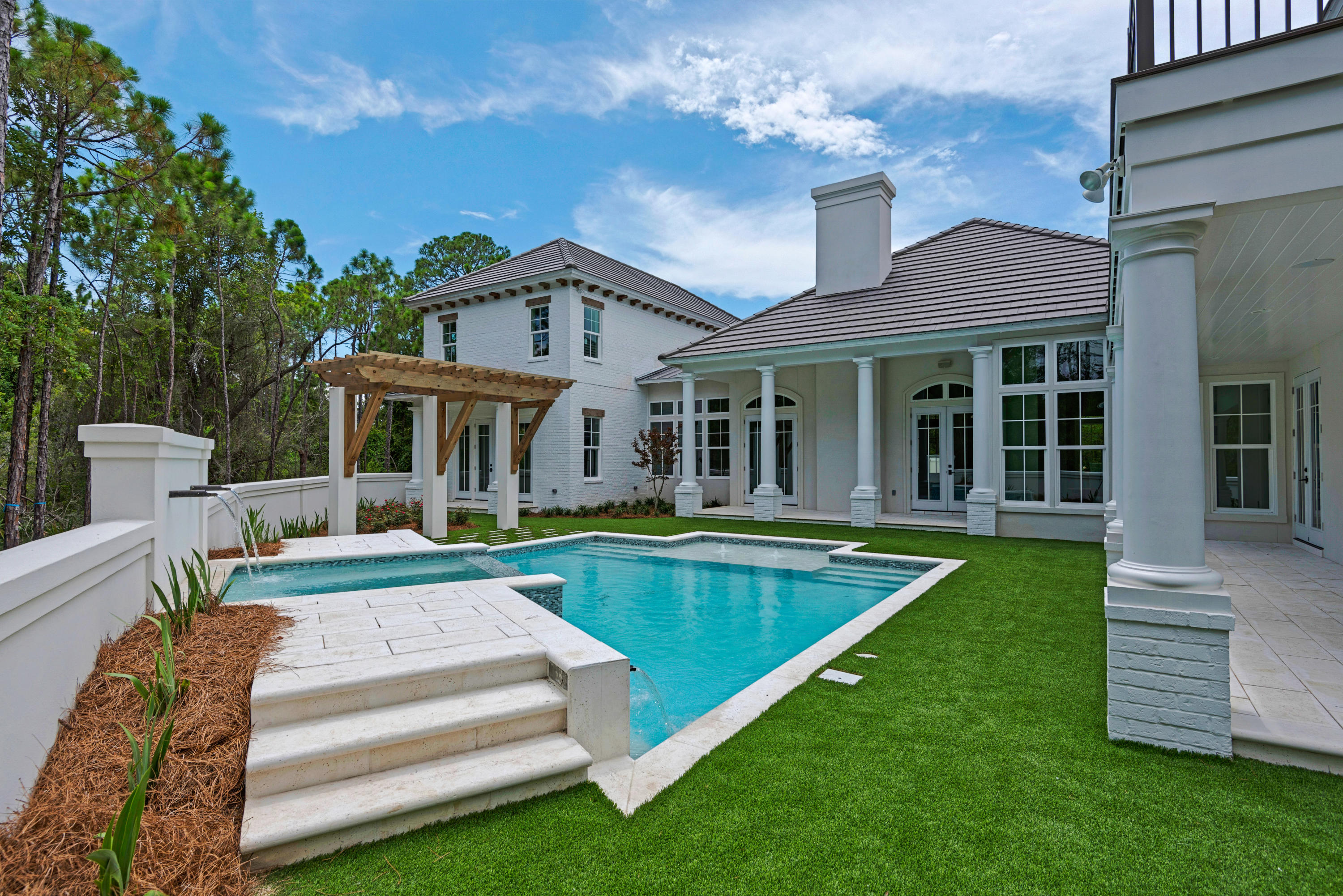 This beautiful 4,432 sq. ft. home in the gated community of Regatta Bay is a true masterpiece. The front courtyard opens to 3 sets of solid mahogany entry doors, and a gallery of archways greets you in the foyer. Custom details throughout the home include pecky cypress and coffered ceilings, a limestone fireplace, handmade cabinetry, and much more. The great room, office, impeccable kitchen and luxurious master suite are located on the first floor. Take the stairs or elevator to the two guest suites and a second kitchen and living room, as well as an outdoor kitchen and large patio on the second floor. The first floor patio is perfect for entertaining by the pool, featuring several fountains. Situated on 1.21 acres and backing up to nature preserve, this home offers incredible privacy.