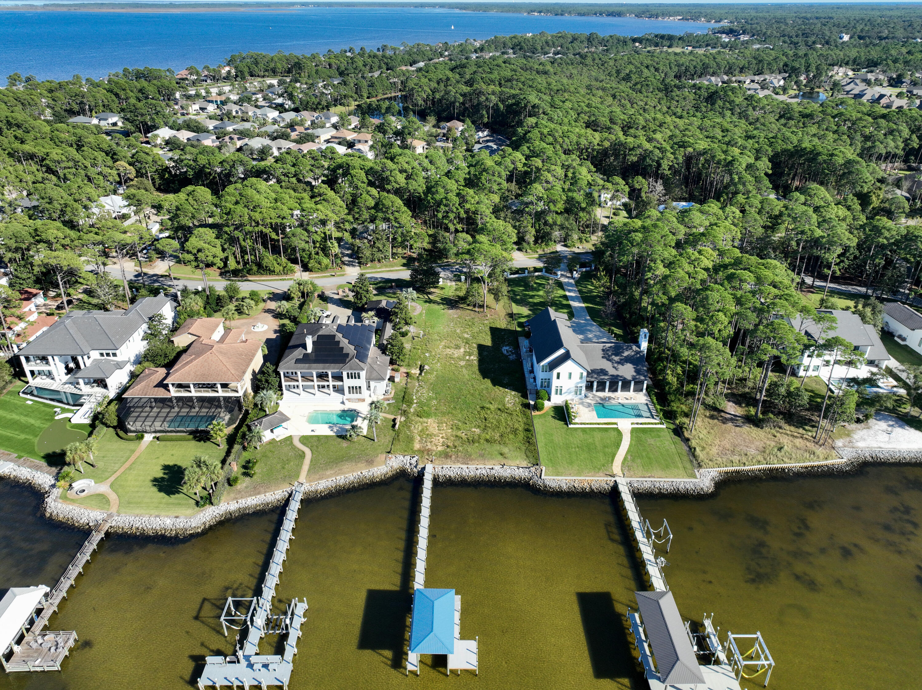 This exceptional, nearly one-acre estate sized lot boasts an impressive 100 ft of bayfront in South Walton's most sought-after waterfront community. Positioned perfectly to capture the breathtaking west-facing sunsets, this property offers a rare combination of location, space, and readiness for your dream home. With a brand-new boat lift and dock already in place, you'll enjoy immediate access to boating and water sports. The lot is fully cleared, prepped, and a permitted set of architectural house plans, significantly accelerating the building process--potentially saving you up to two years of time and effort, are available. Imagine unwinding in your custom-built home with sweeping bay views, private waterfront access, and daily sunset vistas. Whether you want to catch trout and redfish off the dock or enjoy watching the dolphins play, opportunities like this don't come often. Schedule a visit to see this remarkable lot today! Water and Sewer Impact Fees Have been Paid. Boundary and topographical surveys and a full geotechnical analysis are available.