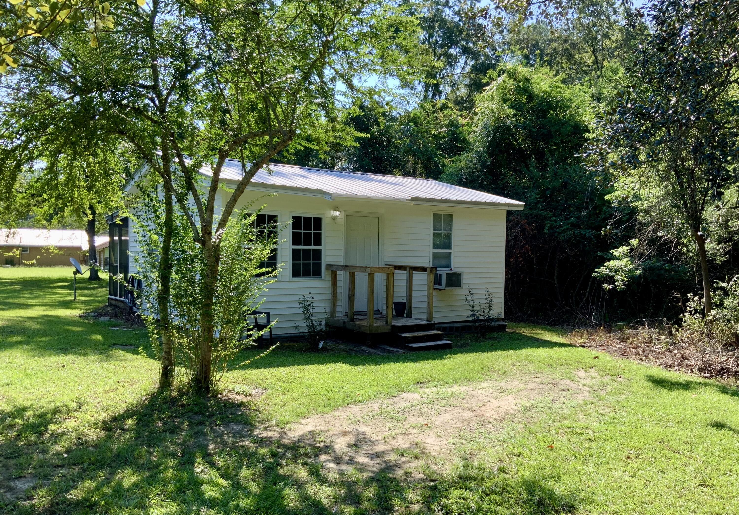 Pending sellers accepting back up offers.A great home in a private location, situated on 3 lots! Less than 1 mile to downtown and Lake Defuniak! Renovated, move in ready, open floor plan, one bedroom, one bath with tub shower combo. Kitchen has newer stainless steel range, refrigerator and plenty of cabinet space! Laminate and tile floors throughout. Screened in back porch to enjoy your morning coffee or afternoon BBQ. Porch has full electric and plumbing. Home has metal roof, been completely re-wired, has newer electrical panel box, new windows, 2020 Hot Water Heater, and 2023 window a/c in living room. Awesome investment/rental home on 3 lots(lots 7,8,9) with plenty of property for new construction! Welcome Home!!