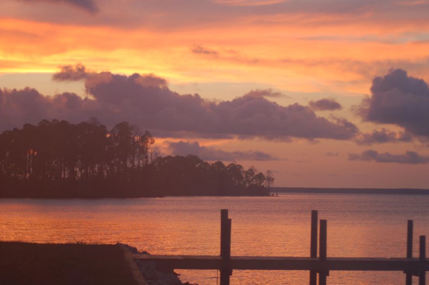 Sunsets west and Sunrises east go with this beautiful bay front lot with 180+ feet of waterfront. You can see both from this lot. The views are more than spectacular! There is a 150' dock and seawall with riprap already in place! All permitting has been done for variances on setbacks to build your home. The 18' wide driveway has been permitted by ACOE and DEP. This is a lot that comes with a ''completed due diligence'' package - new buyer does not have to worry about permitting!! There will never be a house built west of this lot - there are 325 acres of conservation property to the west, so you will have unobstructed views forever. Eagles and Ospreys fly by daily. This property is a dream come true for anyone who loves beautiful views! OWNER FINANCING AVAILABLE! The perfect spot to park your boat and you!