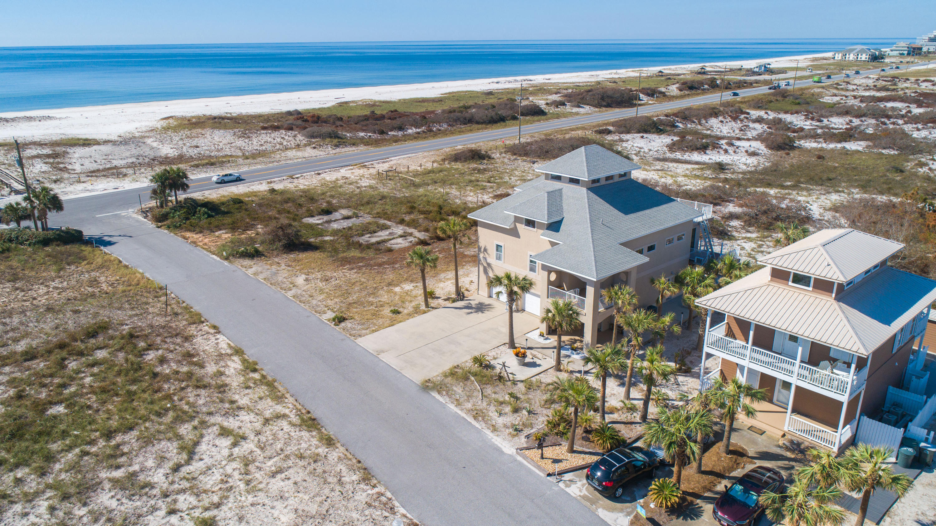 With magnificent Gulf views nestled on Perdido Key, this fortress is built with ICF (Insulated Concrete From) construction, steel framework and concrete pilings, 3 levels of poured concrete floors and an elevator to the second level. You'll enjoy the public beach access directly across the street and countless sunsets and views of Ol' River from the sunroom and top sundeck on the 4th floor with protected views of Perdido Key State Park. The sunroom is encompassed with cork walls and all windows open to enjoy the open air. The spacious living area has vaulted ceilings which flows into the dining area and kitchen. The kitchen comes equipped with granite counter tops, island and ample cabinet storage. The spacious master suite has Gulf views from the bed and comes equipped with an oversized w