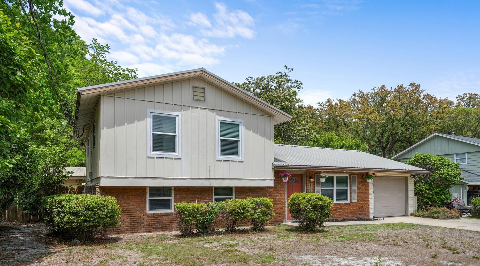 Welcome to 131 NW Sotir St, a tri-level home located in Fort Walton Beach, FL. Situated in the middle between Mary Esther and downtown FWB, your location couldn't be better. Shopping and dining options include Michaels, TJ Maxx, Chilis and Longhorns. For outdoor and recreation activities, you're only 2 mi from Liza Jackson Park, less than 1.5mi from FWB Rec Center and a short 4mi drive to the emerald waters and white sandy beaches of Okaloosa Island. This property features a new lawn pump replaced in April 2025, a water heater from 2020, and a metal roof installed in 2013. The kitchen offers ample cabinets, counter space, tile flooring, a large window for natural light, and a pantry cabinet. On the bottom level, you'll find a bonus living space, a full bathroom with a glass door tiled shower, a bedroom with a pocket door for privacy, and a large laundry room with storage space and your utility space for the w/h and furnace. The second floor boasts real hardwood floors, spacious bedrooms with ceiling fans, and a master bedroom with a screened deck entry point, access to a full bathroom, and floor-to-ceiling double closets. The property is equipped with an ADT-supported security system. Outside, enjoy a large backyard with an open patio space, storage space under the screened deck, and a yard building.