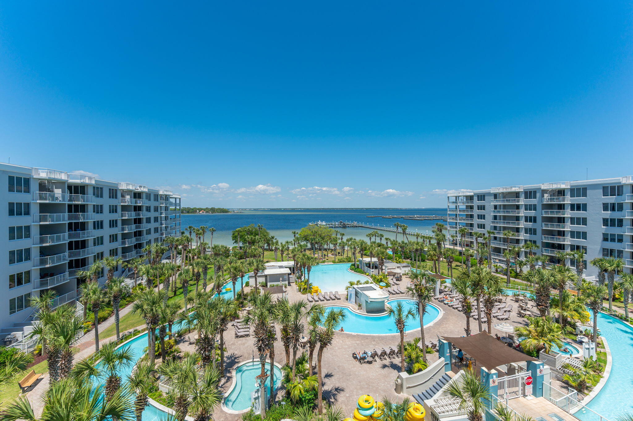 Discover your own piece of paradise at Pelican at Destin West! Immerse yourself in luxury beach resort living with an array of amenities including a serene zero-entry pool, winding lazy river, inviting hot tubs, barbecue/picnic areas, covered parking, marina access, fitness center, and private beach entry. Conveniently situated near top-notch dining and entertainment options, and offering seamless bay and beach access with easy reach to Crab Island, the location is unparalleled. This bay-facing retreat boasts a master bedroom with a full ensuite, a bunkroom with its own bath, and an expansive balcony. Floor-to-ceiling sliding glass doors illuminate the open great room with natural light and offer fabulous views of Choctawhatchee Bay. From the balcony, enjoy front-row seats to the lazy river, marina, and bay activities, from sailboats and windsurfers to playful dolphins. Inside, the spacious living area features a 50-inch TV, DVD player, stereo system, and high-speed internet access. The bunk room includes a 24-inch TV, while the master bedroom offers a 40-inch TV, DVD player, and picturesque Gulf views. The dishwasher, refrigerator, and water heater were all replaced in 2023. The master bedroom and bunkroom have new flooring, and the whole unit was painted in 2021. A convenient skybridge grants direct beach access without crossing Highway 98, and beach service is available for umbrella, chair, and boogie board rentals. Experience luxury living and coastal charm at Pelican at Destin West!