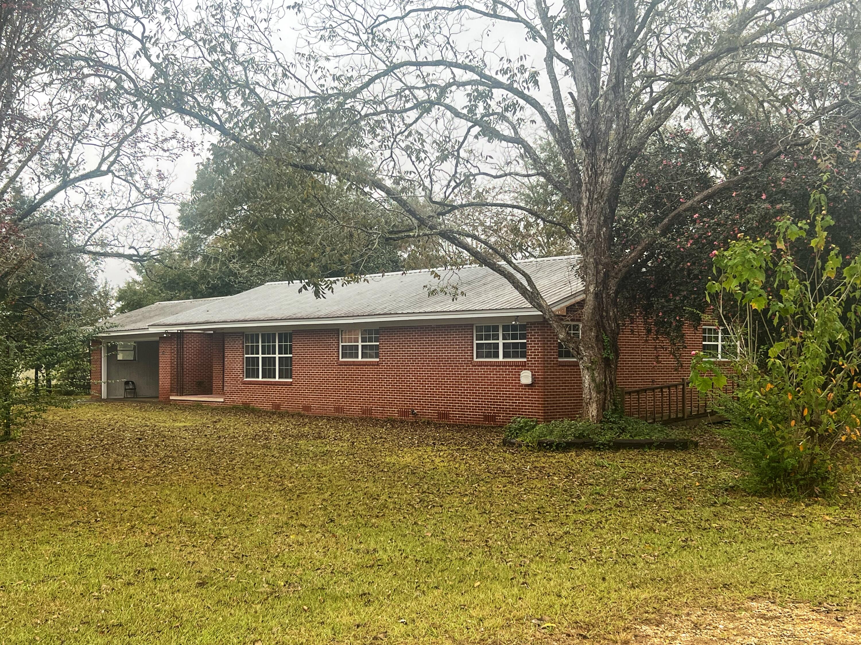 All brick home  on approx. 1/2 acre lot with tons of character showcasing pickwick paneling walls and original hardwood flooring.  Metal roof is approximately 3 years old. The massive 15x44 Florida room offers a second kitchen area.  Conveniently located in the heart of Laurel Hill, next to The Dollar Tree/Family Dollar.  Perfect starter home or  instant rental income for the investor, with the potential to future capitalize on the mixed use zoning. Adjoining property is also for sale.  See MLS #91118