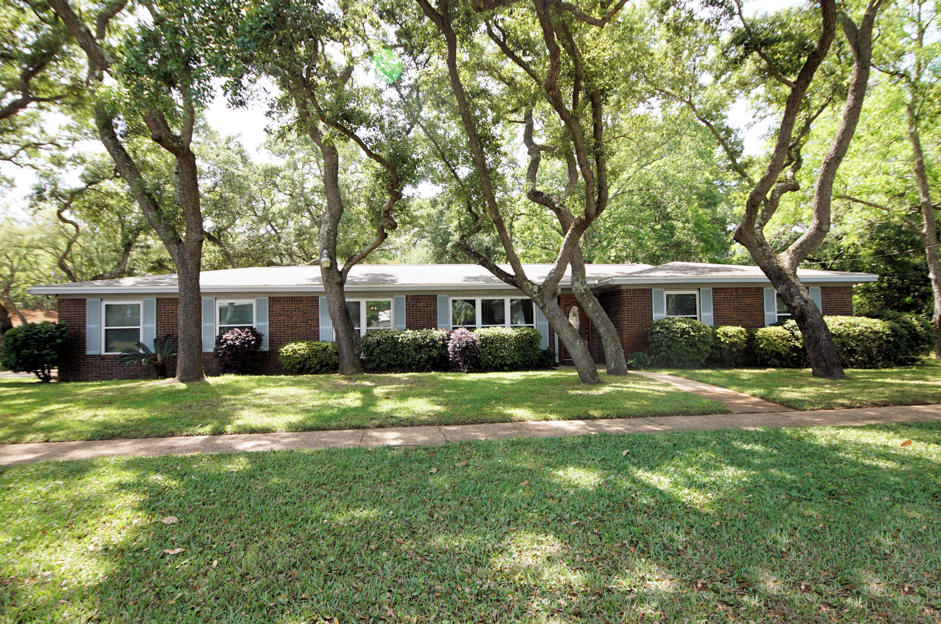 Located in central Ft. Walton Beach, this gorgeous corner lot all brick home is ideal for your family. This three bedroom 2 bath home is close to all shopping, military bases and the emerald coast beaches. Along with the beautiful old trees that surround the home, it has been well taken care of over the years. The large kitchen has an eat in area for a small table, yet you also have a formal dining room for when those special guest come to visit. You will enter the home into a large foyer with a formal living room off to your left. Then you will have a great family room that opens up to the backyard with a beautiful brick wall as an accent wall. Down the hall you have your three bedrooms with the master including an en suite bathroom that has been updated in the last few years. Buyer to verify all dimensions.