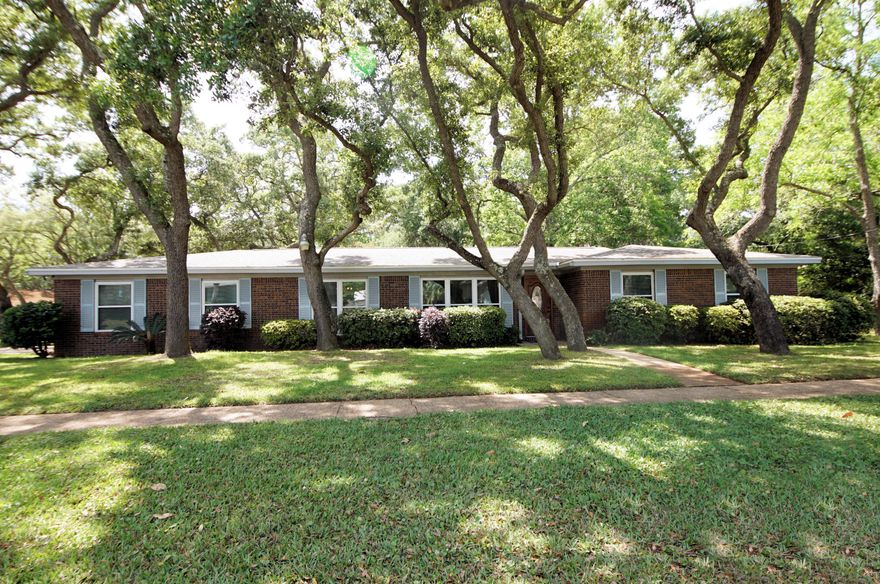 Located in central Ft. Walton Beach, this gorgeous corner lot all brick home is ideal for your family.  This three bedroom 2 bath home is close to all shopping, military bases and the emerald coast beaches.  Along with the beautiful old trees that surround the home, it has been well taken care of over the years.  The large kitchen has an eat in area for a small table, yet you also have a formal dining room for when those special guest come to visit.  You will enter the home into a large foyer with a formal living room off to your left.  Then you will have a great family room that opens up to the backyard with a beautiful brick wall as an accent wall.  Down the hall you have your three bedrooms with the master including an en suite bathroom that has been updated in the last few years. Buyer to verify all dimensions.