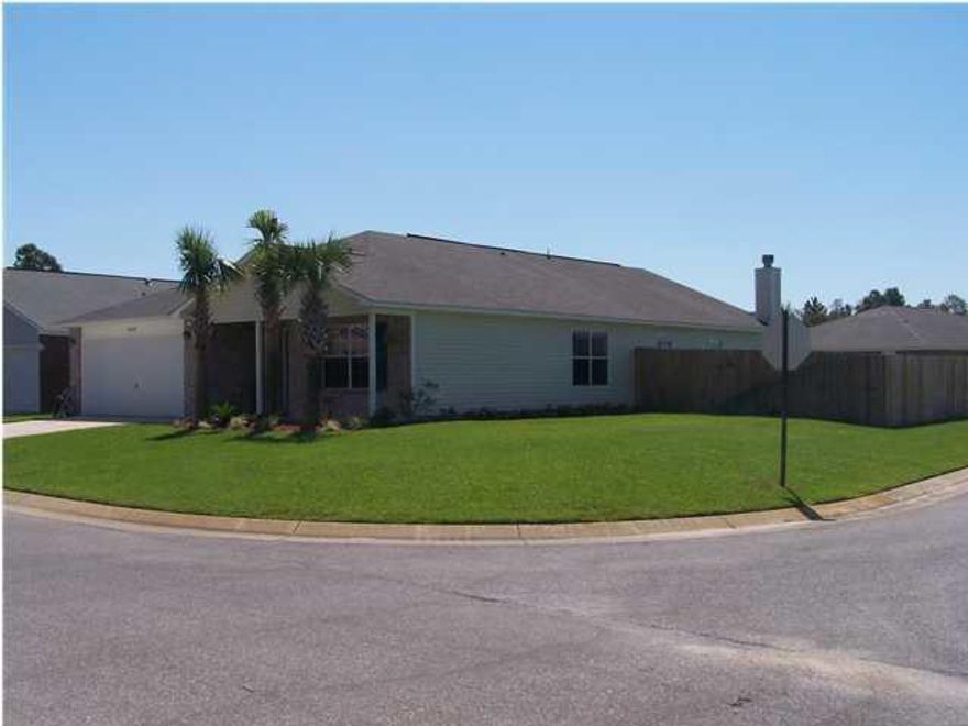 Spacious 4 Bedroom 2 Bath home in the wonderful Hidden Shores Subdivision, conveniently located near Navarre/Gulf Breeze. This lovely home has a split floor plan for privacy and convenience, plus two living areas for family gatherings and entertaining! Living Room /Dining Room in front of home flow into the kitchen area, then into a separate den with a wood fireplace! Large kitchen with center island and Great Room. Master Bedroom has large walk in closet and new flooring. Master Bath has a garden tub and separate shower and double vanities. Beautiful wood laminate flooring throughout Large corner lot allows for lots of play area and family gatherings. Backyard has privacy fence with 3 gates. Automatic sprinkler system with lawn pump and timer. Lowest priced home in the area.