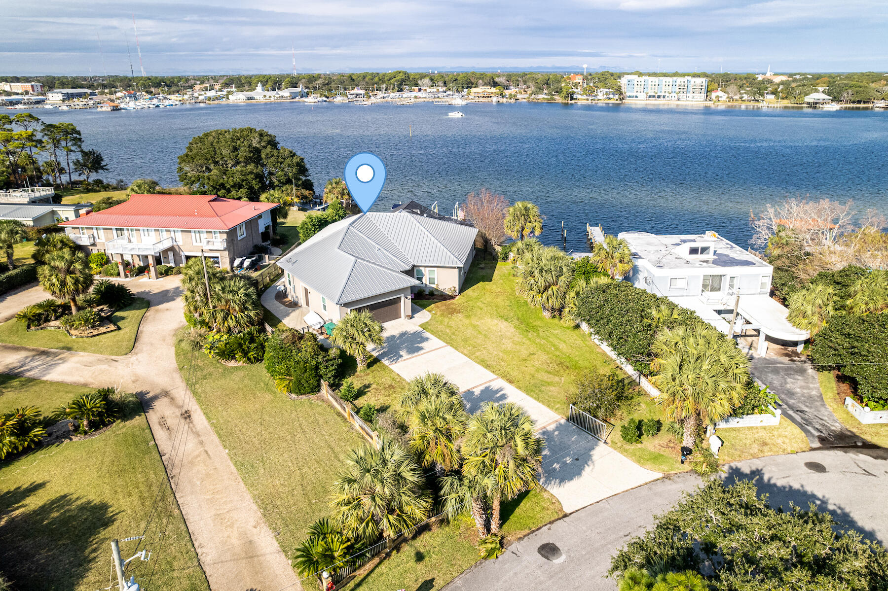This exceptional waterfront estate resides conveniently on Okaloosa Island and offers 88 feet of Sound front footage and comes equipped with 2 boat lifts/jet ski lifts (20,000 and 16,000 pounds built by Frank Davis of Davis Construction). With outstanding craftsmanship and built with Insulated Concrete Form construction (which ensures low insurance), this home offers a screen enclosed heated saltwater pool and spa, additional garage for a golf cart, and commercial ice machine. With a wonderful flow and open spacious floorplan, this home make the perfect place for entertaining guests. The kitchen comes equipped with custom cabinetry and soft close drawers providing ample storage with pull out drawers, 6 burner gas hood range cooktop, prep sink, water filtration system, wall oven and built-i