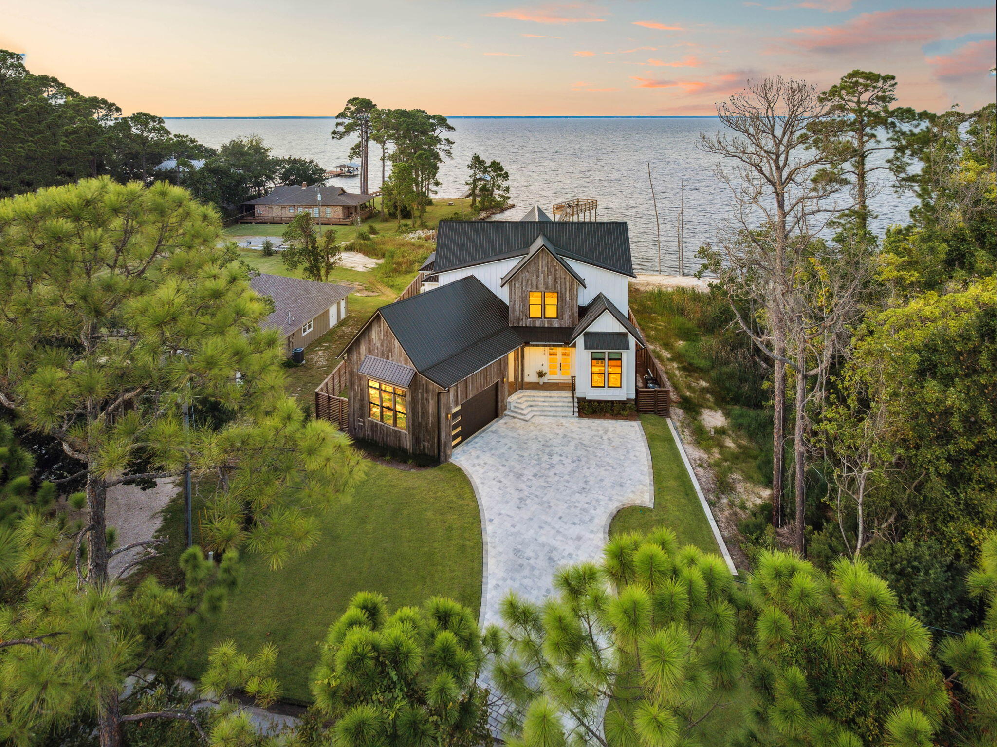 Welcome to this stunning new construction bay-front home in Miramar Beach, offering 3,035 square feet of well-designed living space. This property features four bedrooms and five bathrooms, along with a dedicated office and versatile loft, providing plenty of room for both comfort and functionality.The home boasts over 550 feet of covered porch, perfect for enjoying the beautiful bay views. A detached carriage house offers additional space for guests. For water enthusiasts, the private dock comes with a boat slip, making bay access easy and convenient.Enjoy the luxury of a heated and cooled pool and spa, ideal for relaxation and entertainment. The second-story viewing deck provides a perfect vantage point for taking in stunning sunsets or hosting gatherings. The oversized insulated and climate-controlled garage offers ample space and convenience for any storage or hobby requirements. With no HOA, you can enjoy your property without additional restrictions.
This Miramar Beach home seamlessly combines modern design with the charm of waterfront living. Schedule a private tour today to experience this exceptional property firsthand.