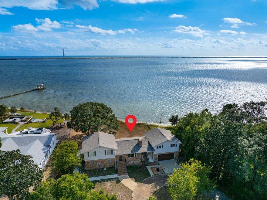 Panoramic view of beautiful Santa Rosa Sound and unspoiled Santa Rosa Island! Perfect sunsets from deck! This one-owner waterfront home features brick construction, stainless-steel appliances, Mission-style cabinetry, bay window, renovated baths (one accessible), crown-moulding throughout, two wood-burning fireplaces, & central vac system!  The large storage area over garage is an added bonus with tons of potential!  Renovate as a Primary Master Suite OR AirBnB OR long-term rental-both with a separate entrance! Spacious bonus room is a great man-cave, playroom or movie room!  Fully-fenced backyard! Workshop/Storage building! Newer seawall!