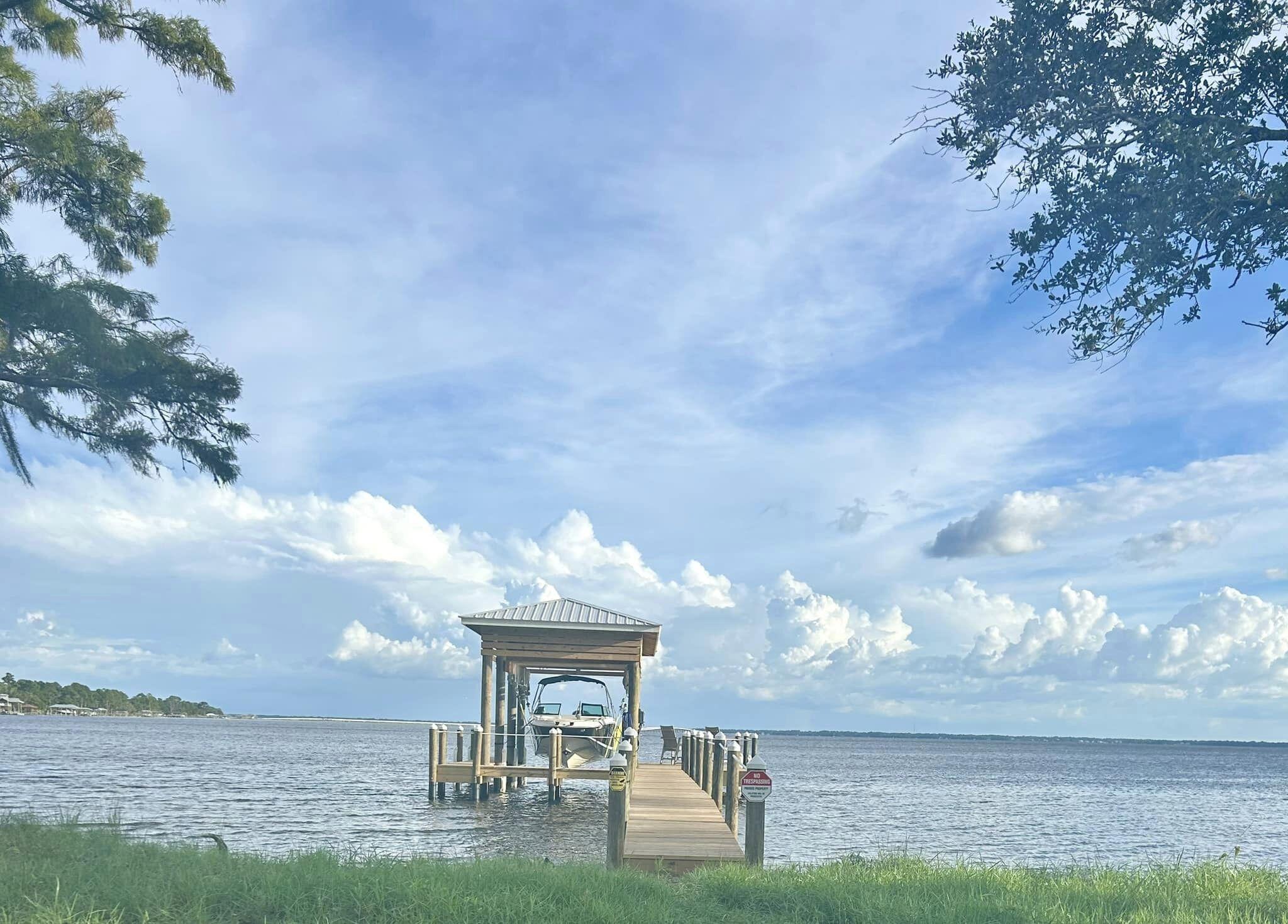 Beautiful Bay Front Lot with Southern Views toward the 331 Bridge. Cleared lot with TAP FEES ALREADY PAID & BRAND NEW BOAT DOCK with WATER AND POWER. Boat lift installed with a 12,000lb capacity and can accommodate a boat up to 30ft in length. Perfect for your bay or center console boat! Boat, fish, Yolo or jet ski from your Bay front Paradise. Easy trip to North Beach Social or The Bay Restaurant! Don't miss this incredible opportunity to build your dream bay front paradise!
