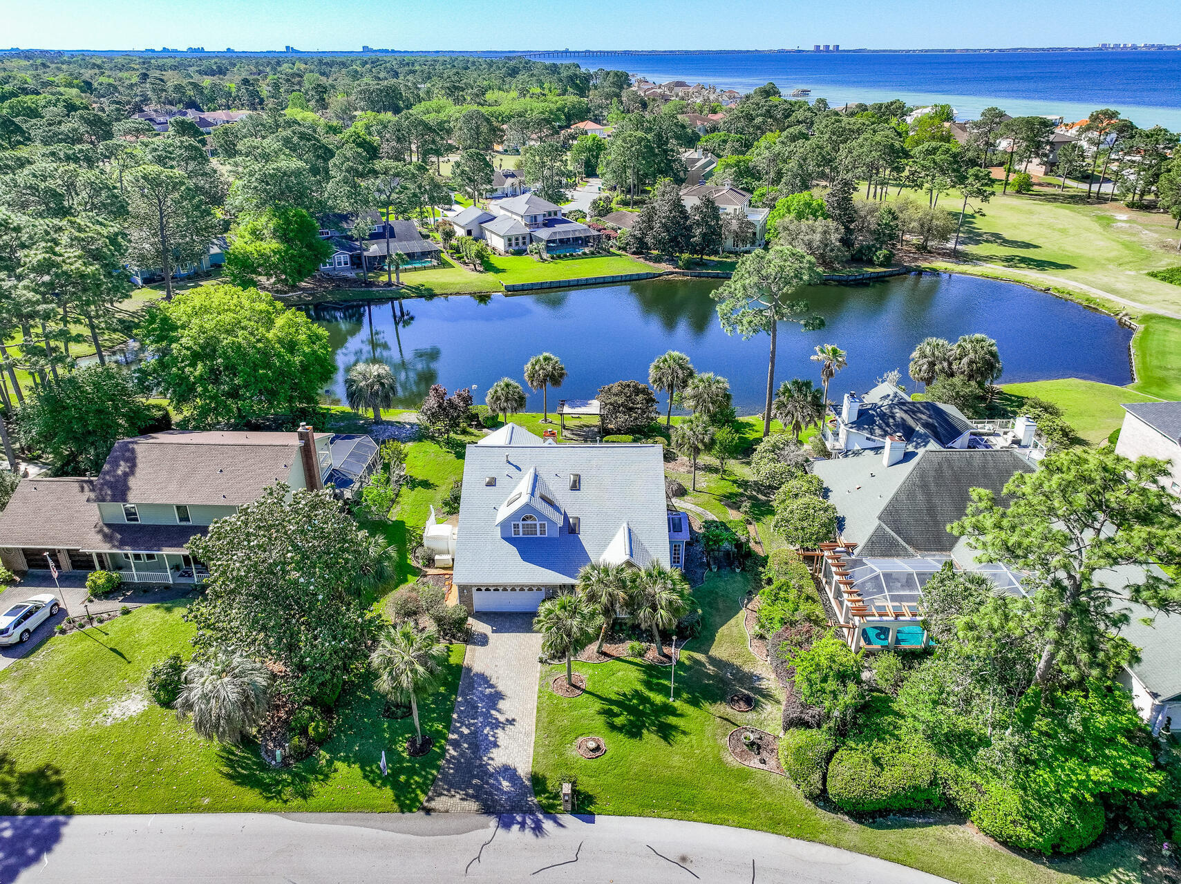 LAKEFRONT LIVING IN GATED SOUTHWIND - ROOM TO UPDATE, VIEWS TO INSPIRE. One-owner lakefront home in the gated community of Southwind, Bluewater Bay. This 3 BED, 3 BATH home offers 2,924 SF of space, with all bedrooms upstairs--including a SERENE PRIMARY SUITE W/ COVERED BALCONY OVERLOOKING THE LAKE. Enjoy formal living and dining rooms, an open kitchen/den with gas fireplace, and a SCREENED-IN GUNITE POOL perfect for relaxing. Gas stove, heat and water heater, FULL HOUSE GENERATOR AND CENTRAL VAC, and some newer windows already in place. PEACEFUL SETTING, tons of potential--bring your vision!