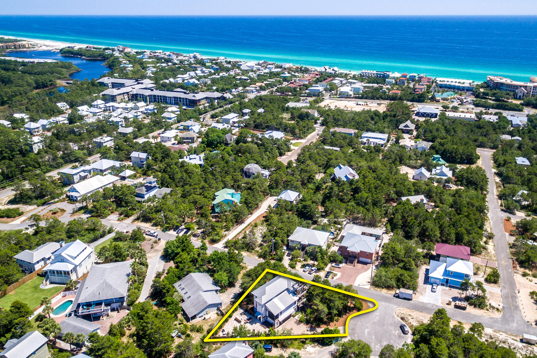 Atop a bluff overlooking 30A's Blue Mountain Beach, this beautiful home features 3 floors plus a roof-top deck with rare 360-degree views! The unique floorplan offers indoor and outdoor spaces that service the full range of activities of the desirable Emerald Coast lifestyle. The large, open living room/dining room/kitchen with vaulted ceiling and gorgeous Brazilian cherry wood floors makes a great backdrop for entertaining. Outdoors, the fabulous, spacious outdoor patio with summer kitchen, grill, outdoor dining area, and hot tub will host picnics and magical evenings amongst natural surroundings! The many decks offer a variety of other spaces to enjoy the fresh sea breezes, shady pines, or warm sun.The main-floor bedroom suite will suit guests, or would make a convenient office.