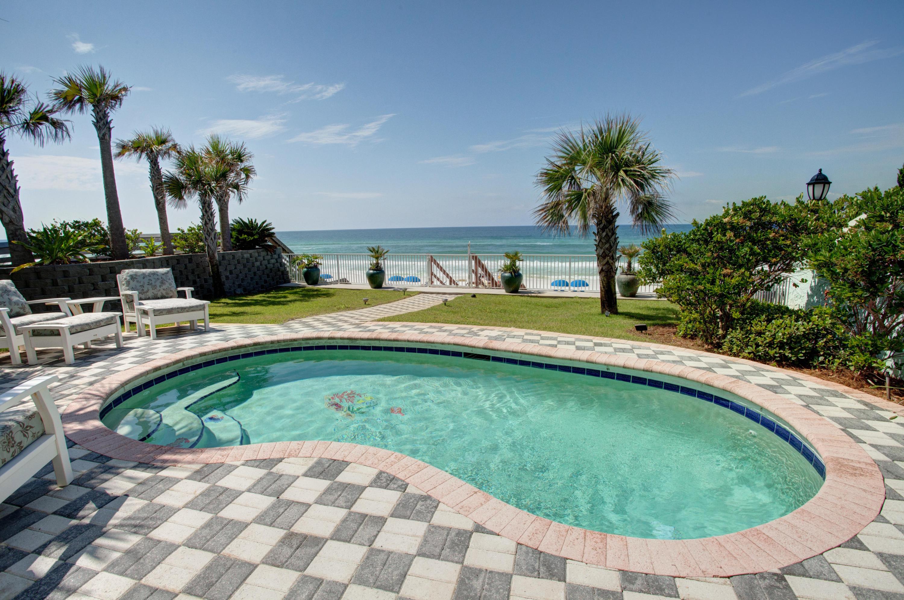 Idyllic Florida beach home on the Gulf of Mexico in Miramar Beach. Perched on a dune overlooking the gulf, this lovely 5+ bedroom beach cottage enjoys private access to 50 feet of sugary white sand! The home is reminiscent of Miami style with its art deco features and a private courtyard, yet it also features modern upgrades such as tile flooring, granite countertops, custom tiled showers, and more. The first-floor living room of the main house enjoys great gulf views and access to the patio/pool, while the 2nd floor offers another large living space with a large deck and more great sunset views. The stairs rise up next to a glass block wall which lets in the light.The master bedroom also faces the water and patio. The master bath offers a garden tub, separate tile shower, two sinks..
