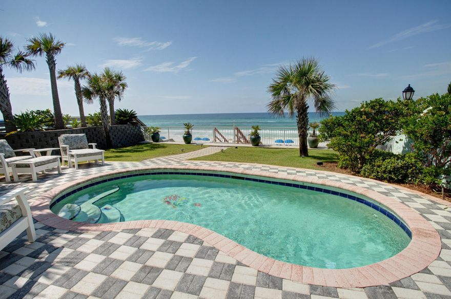 Idyllic Florida beach home on the Gulf of Mexico in Miramar Beach. Perched on a dune overlooking the gulf, this lovely 5+ bedroom beach cottage enjoys private access to 50 feet of sugary white sand! The home is reminiscent of Miami style with its art deco features and a private courtyard, yet it also features modern upgrades such as tile flooring, granite countertops, custom tiled showers, and more. The first-floor living room of the main house enjoys great gulf views and access to the patio/pool, while the 2nd floor offers another large living space with a large deck and more great sunset views. The stairs rise up next to a glass block wall which lets in the light.The master bedroom also faces the water and patio. The master bath offers a garden tub, separate tile shower, two sinks..