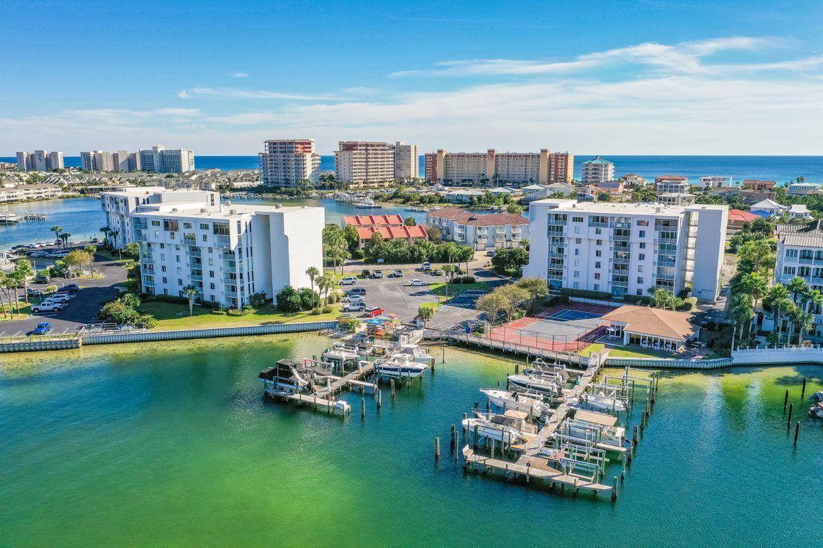 Located on exclusive Holiday Isle, this rare ground floor end unit at Dolphin Point offers a lifestyle of convenience and entertainment. Unit 106A boasts two spacious bedrooms and bathrooms and features an updated kitchen, tile flooring throughout the living area, an enclosed patio that provides extra living space, a two year old water heater and an interior washer and dryer. Dolphin Point is located directly on the harbor and is the perfect retreat for those who love life on the water. Recent improvements to the building include resurfacing of the parking lot, wiring installation for WiFI and a new plumbing supply line. Dolphin Point features impeccable amenities including beach access, a marina, tennis courts, a community pool, an owner's clubhouse, grills, an on-site manager and kayak