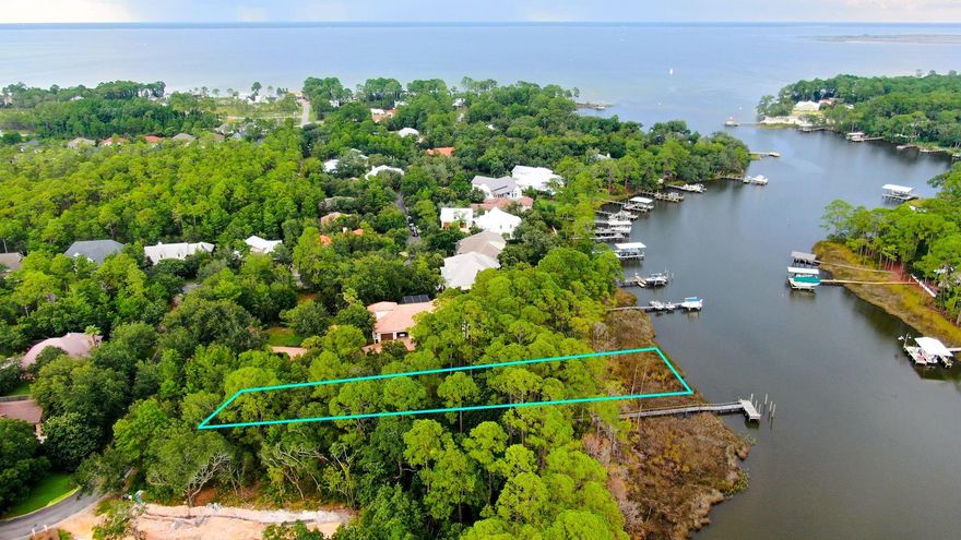 Last buildable lot on the water in the beautiful gated subdivision of Botany Bayou.  Homesite is about 5 minutes to our stunning white sugar sands of the Emerald Coast...truly the best of both worlds.  Drop your boat to have access not only to the bay, but also to the Gulf Of Mexico.  Plenty of room for a private pool, or take advantage of the community pool that is already in place.  This lot is almost a full acre on Hewett Bayou, covered with mature live oak trees. Build your custom dream home.