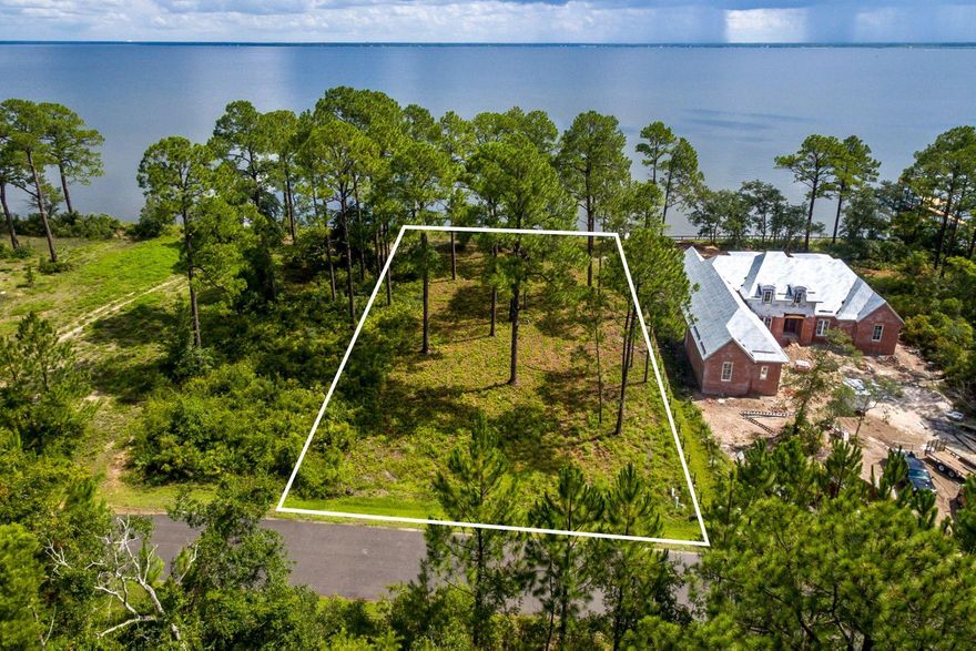 Your boating lifestyle awaits you with this spacious home site that delivers waterfront living in the home design of your dreams. Experience the bay breeze from your front porch, slip into your private pool, add your own dock, and landscaping to create a personal sanctuary. Seclusion Bay is a private, gated community with No Build Out Time Frame, only 53 estate sized lots, and modest association fees of $50 per month. This lot is just under half an acre with seawall shoreline protection and is in Flood Zone X, a rare status for bay front homes. Fifteen acres of preservation in the neighborhood provide natural surroundings and exceptional bird watching, with visits from osprey and even bald eagles. Within minutes you can be on the beach or be enjoying good eats at top notch restaurants.