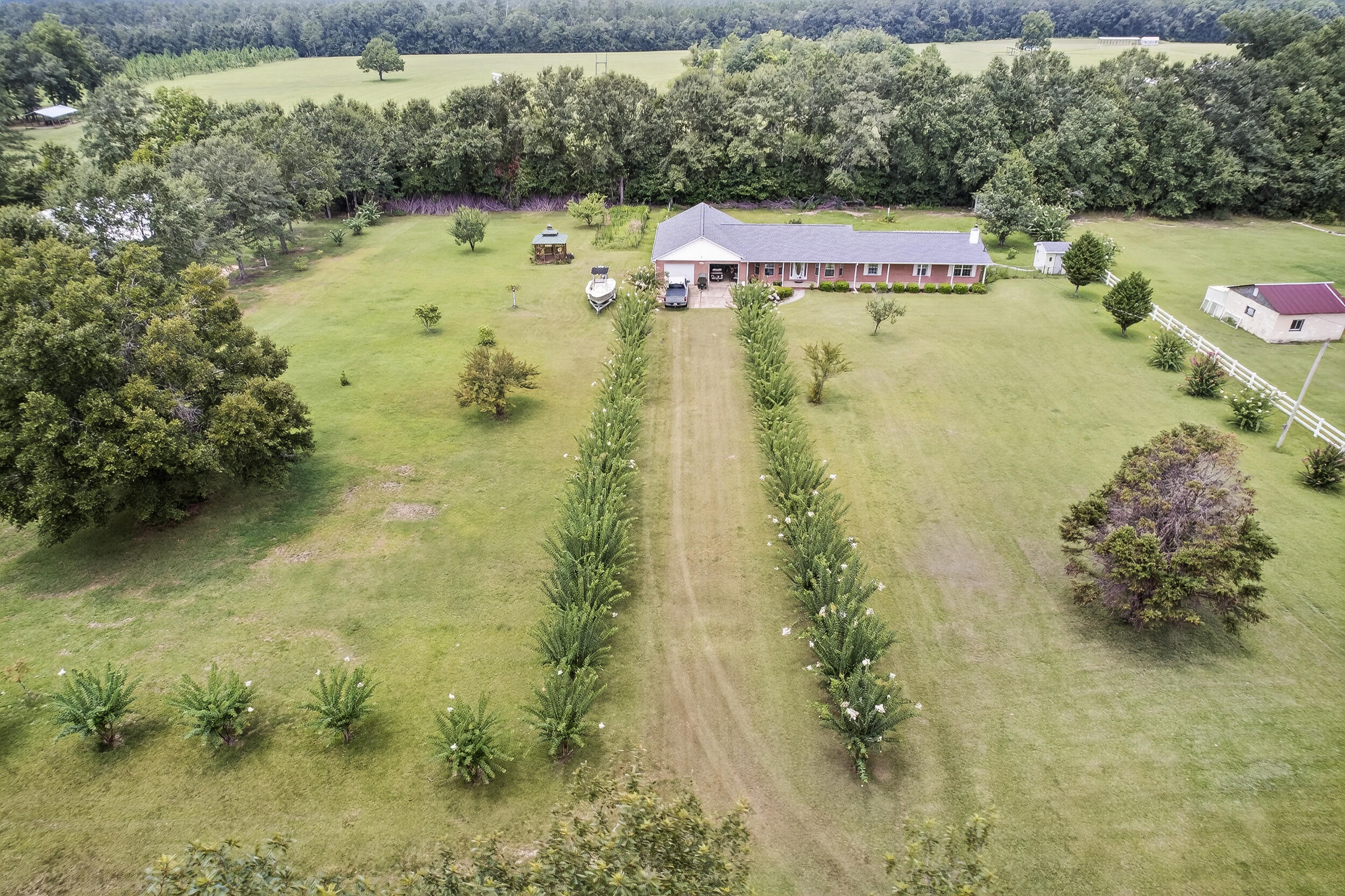 Enjoy private living in this 4-bedroom, 3-bath home on 2.16 private acres in Molino. Set back on a quiet road, this home offers true privacy with mature trees, plenty of open space, and room to expand or enjoy the outdoors. Thoughtfully designed and move-in ready, this property offers both comfort and flexibility. The home includes 2 full bathrooms inside the main residence and an additional full bath in the detached garage--ideal for a workshop, hobby room, or future guest space.Inside, a large flex living area opens seamlessly to the kitchen, creating an open-concept layout perfect for entertaining or everyday living. Use the space as a formal dining area, second living room, or home office--the possibilities are endless. The L-shaped family room features a cozy fireplace, automatic window blinds, closet space, and plenty of natural light, along with direct access to the backyard.
The spacious master suite (20x13) is your personal retreat with two walk-in closets, dual vanities, a jetted soaking tub, and a separate walk-in shower.
Additional highlights include a generously sized indoor laundry room with built-in cabinets, a laundry sink, and a fold-away ironing board, plus a screened-in patio for relaxing year-round.