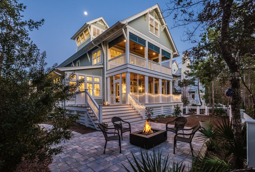 This four-story lakefront home greets you with the glow of gas lanterns, a spacious covered front porch with stately blue board and batten shutters and an accentuated shiplap ceiling that adds warmth to the space. This WaterColor home offers a coveted main floor master suite and a bonus bunk room with fun and functional living space on each level. A cozy seating area arranged for conversations and a front porch swing create the perfect place to unwind after a day at the beach. Large windows with transoms flood the welcoming foyer wrapped in shiplap with natural light. The soaring ceilings pull the eye upwards and an exposed brick accent wall draws you into the space. The warm walnut floors lead you to the heart of this 4,433 square foot home, where you will find an expansive