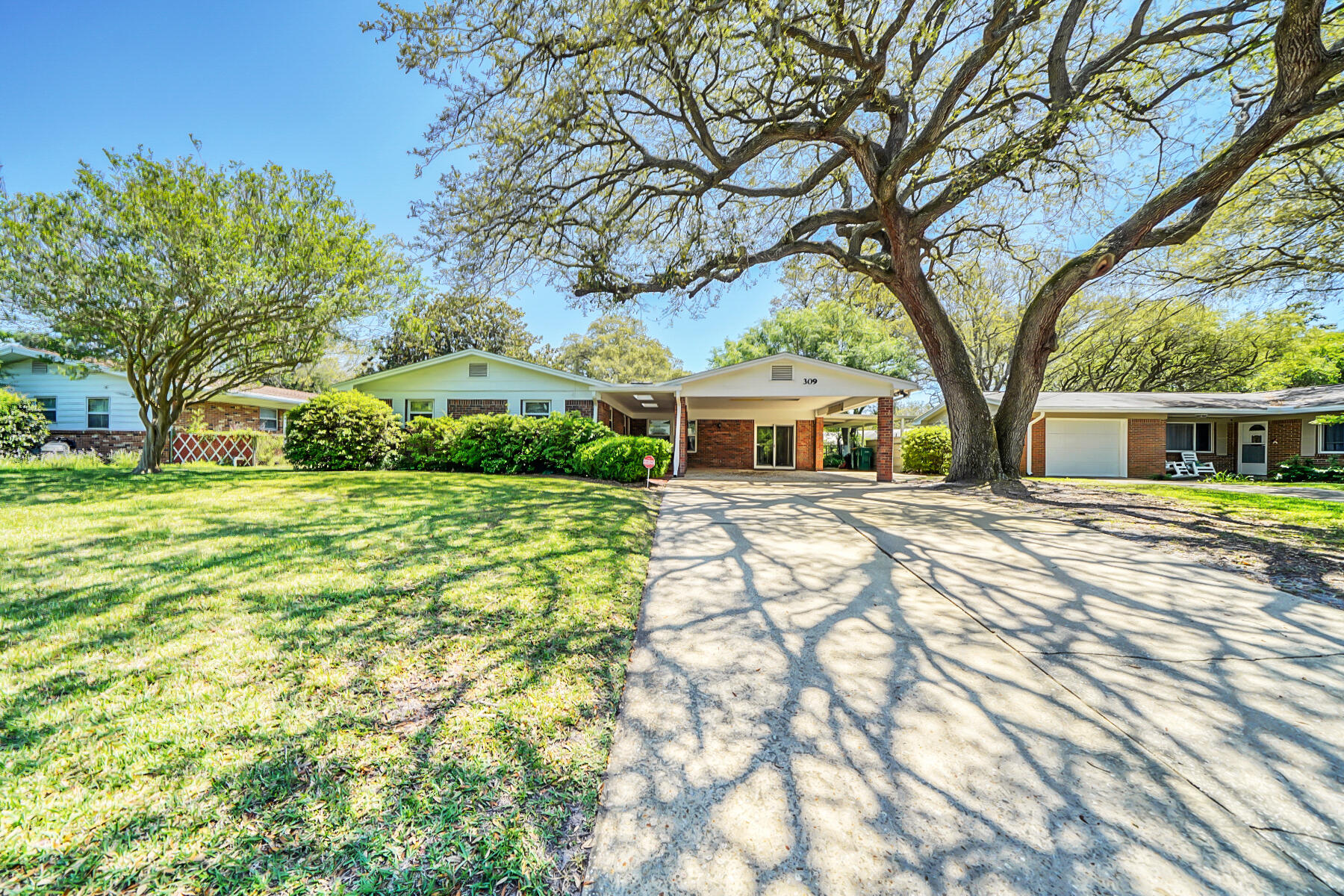 Beautiful brick home surrounded by lush azaleas and large lawn. Refinished Parquet flooring throughout and freshly painted walls add to the beauty of this home. Relax on covered screened porch overlooking fenced back yard. Home features plenty of living space including a Formal Dining room off the kitchen as well as a Living Room plus a Family room. One of these main living areas or one of the 3 bedrooms could be used as a home office. Kitchen features a center island with seating. When entering home, park in the carport and enter through either the front door to the foyer or the sliding doors to the family room which leads to the kitchen. Convenient to shopping, schools and Eglin or Air Force Base or Hurlburt Field as well as beaches.