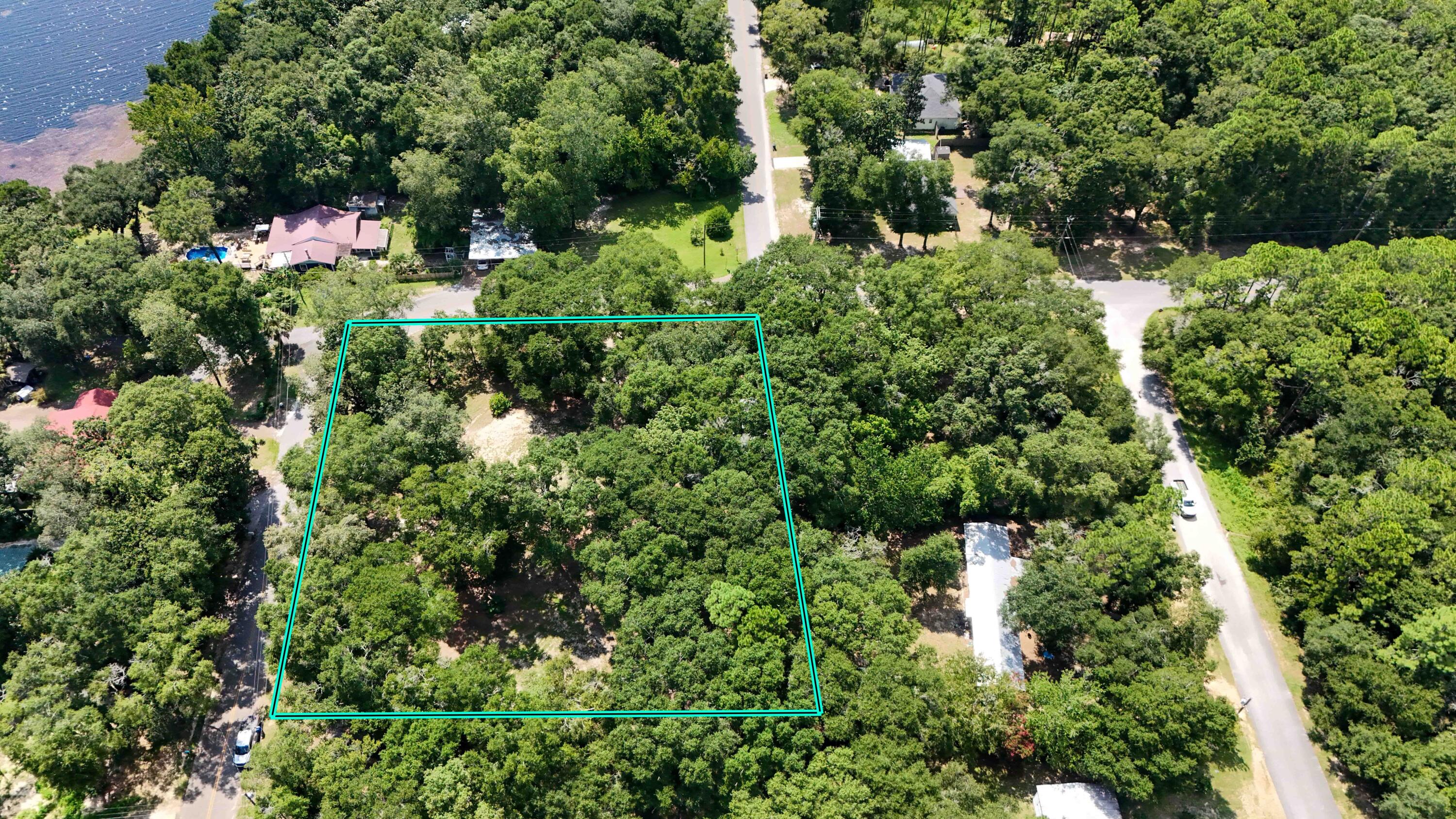 Build your dream home with a waterview on the beautiful 600-acre Juniper Lake! This rare opportunity offers one of the largest parcels of land with an incredible view of the lake, situated on an elevated one-acre corner, composed of two half-acre parcels, perfect for building one or even two homes and has been cleared of previous structures to provide a perfect canvas for your vision of a serene lakeside retreat.Enjoy not only the stunning views but also a refreshing breeze from the lake, enhanced by the fragrant aroma of gardenias in bloom. The property features HUGE HARDWOOD trees, partial fencing, and a spacious storage shed. Utilities are already in place, with electric and water services available. Just a short drive from the charming, historic, town of DeFuniak Springs.