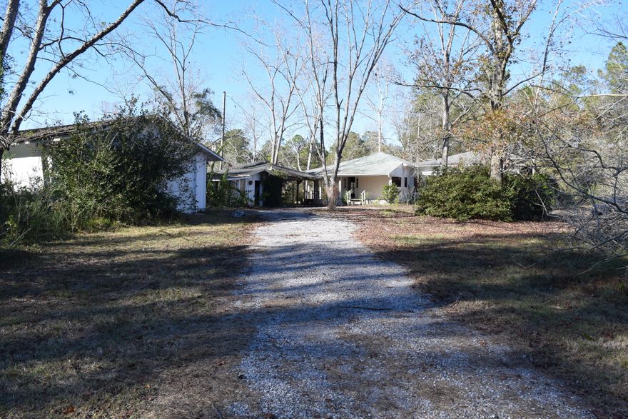 CHARM, CHARM, CHARM! Come fall in love with this traditional, 1940's farmhouse! The potential will amaze you!! Situated high and dry on over 5 acres, this property is someone's dream come true! The rooms are HUGE, the ceilings are TALL, and there are rooms for whatever you need space for! Bring some rocking chairs for the front porch, which is the whole length of the house. The brick fireplace in the living room covers the entire wall. The property is full of trees and shrubbery and places for kids to explore! One of the outbuildings has potential for additional living space (guest house maybe?) This one is worth checking out!
