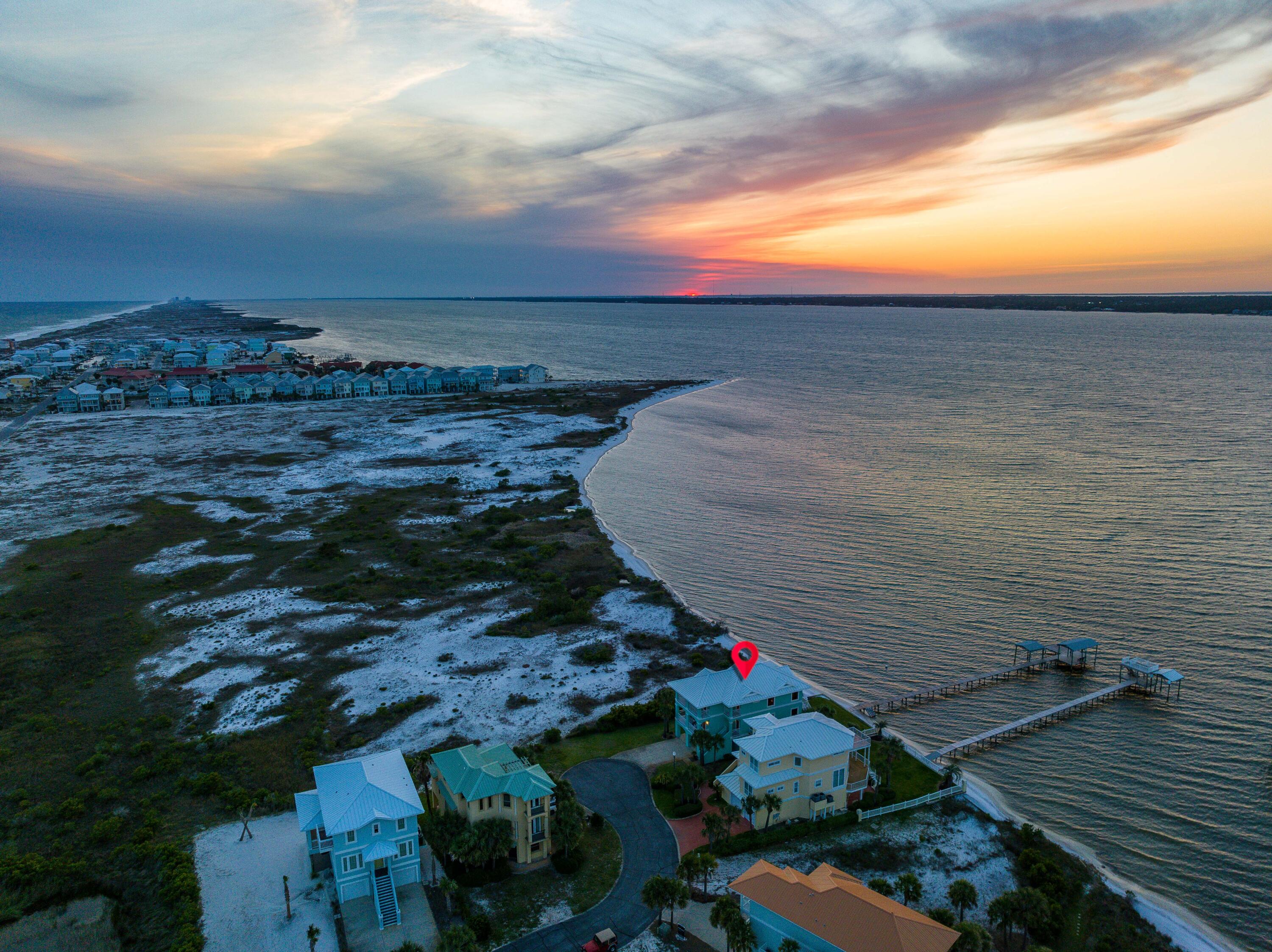 One-of-a-kind Soundfront Eden embodies the Quintessential Florida Lifestyle on Navarre Beach. Florida's Most Relaxing Place. Premiering unparalleled views, this 4 bed 3 bath home borders County Conservation land to the West ensuring Undisturbed Water Views and Pristine Sunsets.You and guests can enjoy every day on the water in your own backyard with a private beach, private dock, boat lift, boathouse, & mooring ball.Heated outdoor shower is perfect for rinsing off after water-filled day.Open-concept kitchen, living, and dining areas are thoughtfully designed to take advantage of the Sound views and incredible sunsets.Soft close cabinets and drawers are added bonus, making entertaining a breeze. Multiple balconies offer outdoor spaces to entertain, relax & absorb the tranquil atmosphere.