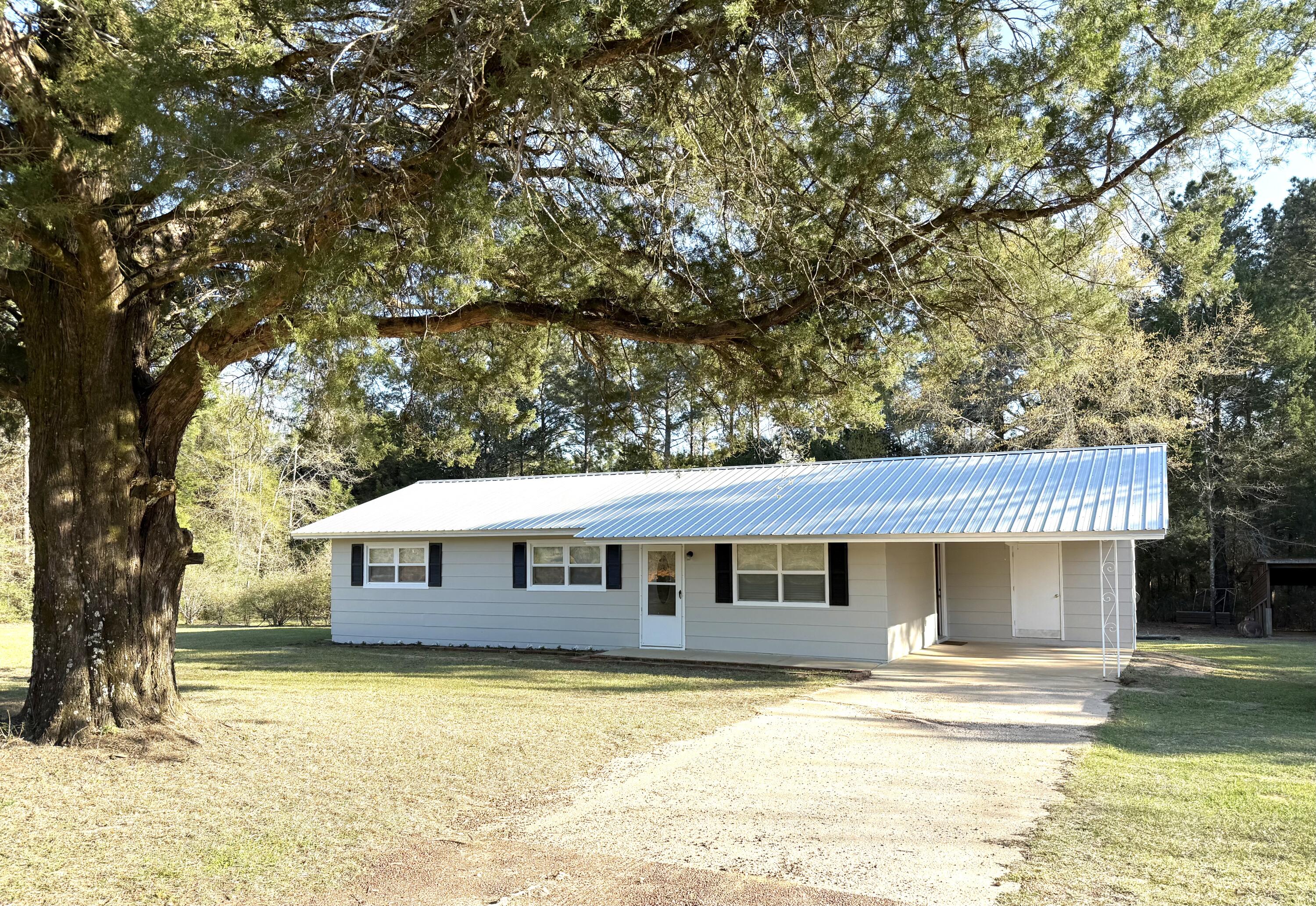 Charming 3-bedroom, 1-bath home located just north of DeFuniak Springs features metal roof installed 2013, newer windows, new exterior paint, and tile that transitions into new carpeting in the bedrooms. Electrical, HVAC, and Septic tank updated 2005, and hot water heater 2025. Survey is also on file. Step outside and enjoy new deck for morning coffee or late afternoon cookouts. Yard boasts fertile blueberry and blackberry bushes and large chicken coop, and a versatile pole barn that accompanies a workshop with a practical lean-to - perfect for the handyman. It is evident that property has been well maintained and this is truly a move in ready home in the country. Perfect for primary residence or rental.