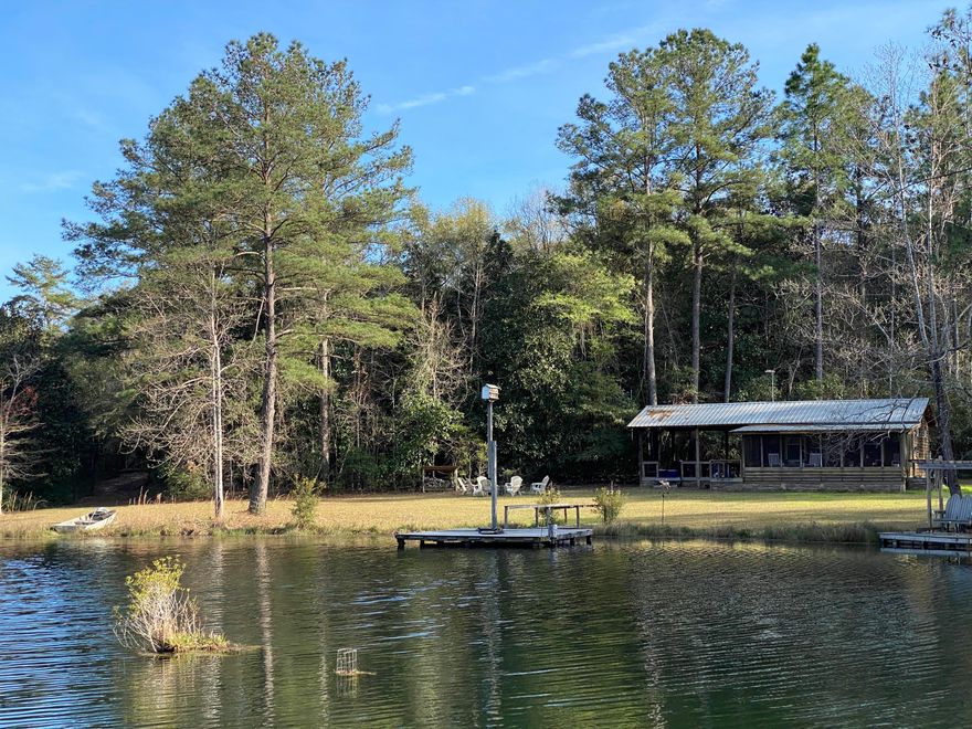 Off Grid cabin overlooking the 2 Acre lake on almost 78 Acres in God's country!! One room cabin with bed, kitchen and living area with huge deck and porch overlooking the lake! Hardwoods, Planted pines lots of paved road frontage!