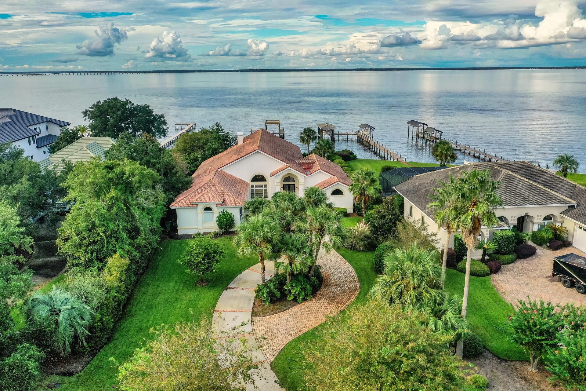 Enjoy the most beautiful sunrises and sunsets at this beautiful bay front home in Emerald Bay. Boat lovers will be in heaven with the recently updated boat dock, which includes space for your boat and jet skis. The dock has new Trex decking and the boat lift pilings were also replaced. There is even a personal beach area, complete with white sand, added within the last 3 months. New, controlled LED lighting and an upgraded saltwater system were added to the pool. Inside you will find wide open spaces with two living areas (one currently used as a game room), large dining area and a spacious kitchen.