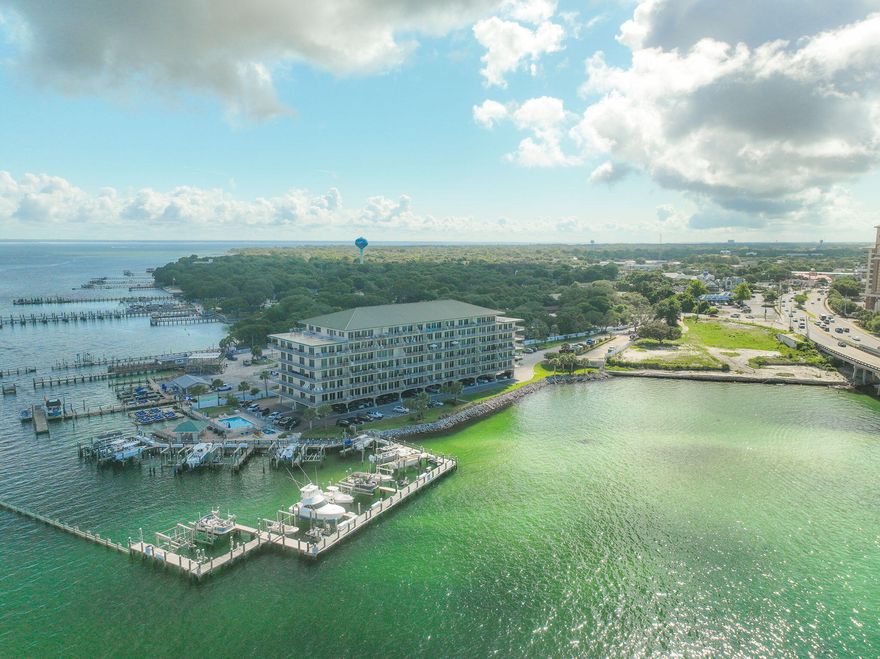 Experience the spectacular 180-degree views of the Destin Harbor entrance, the East Pass, the Gulf, and Crab Island from the expansive 378 sq. ft. balcony of this stunning 3-bedroom, 3-bathroom condo located in the heart of Destin. Situated on the fifth floor of Sides Moreno Point West, this 2,367-square-foot residence offers a rare blend of privacy, luxury, and breathtaking water views. The stunning custom kitchen features granite countertops, stainless steel appliances, a 2023 LG ThinQ refrigerator with a dual ice maker, a wine refrigerator, a wet bar, double ovens, a built-in microwave, ample pantry space, and a breakfast bar. An open floor plan offers water views from nearly every angle. The unit was repainted and new luxury vinyl plank (LVP) flooring was installed in 2019. The balcony was retiled in 2020, and custom solid-core doors have been added throughout. Enjoy direct balcony access offering south-facing water views from the living room, as well as both the primary and second bedrooms. New light-blocking powered blinds were installed in the primary bedroom and the living room in 2022.  New white blinds were installed in the second bedroom in 2025 (and also conveys with a large firearms safe located in the closet).  The primary ensuite bathroom features dual vanities, a large step-in shower, and a walk-in closet (equipped with a safe). The third bedroom, designed as a home office, faces north and captures breathtaking views of Choctawhatchee Bay. This space includes built-in desks, shelving, and a Murphy bed, providing both functionality and flexibility. Additional highlights include a spacious laundry room featuring a front-loading washer and dryer, a sink, and ample built-in cabinetry. This unit also features metal hurricane shutters that can slide shut in under 10 minutes, providing added peace of mind. Community amenities at Sides Moreno Point West consist of a bay-front pool, a gazebo with two gas and two charcoal grills, a guest dock, and a marina (no slip ownership conveys with this sale, but a slip with a lift is available for lease for one to three years - see description in the documents tab).   The current owner is leasing the slip. A 2021 Bennington Fish & Ski Pontoon Boat can be conveyed with an acceptable offer or negotiated separately. One garage parking space is included, along with unlimited outdoor parking. This rental-restricted community (no short-term rentals - one rental every 30 days only) is pet-friendly (for owners only, with a 40-pound limit) and also features a Community Room with a catering kitchen for private events. Enjoy front-row seats to Destin's Harborwalk fireworks from Memorial Day through Labor Day, along with special holiday shows.