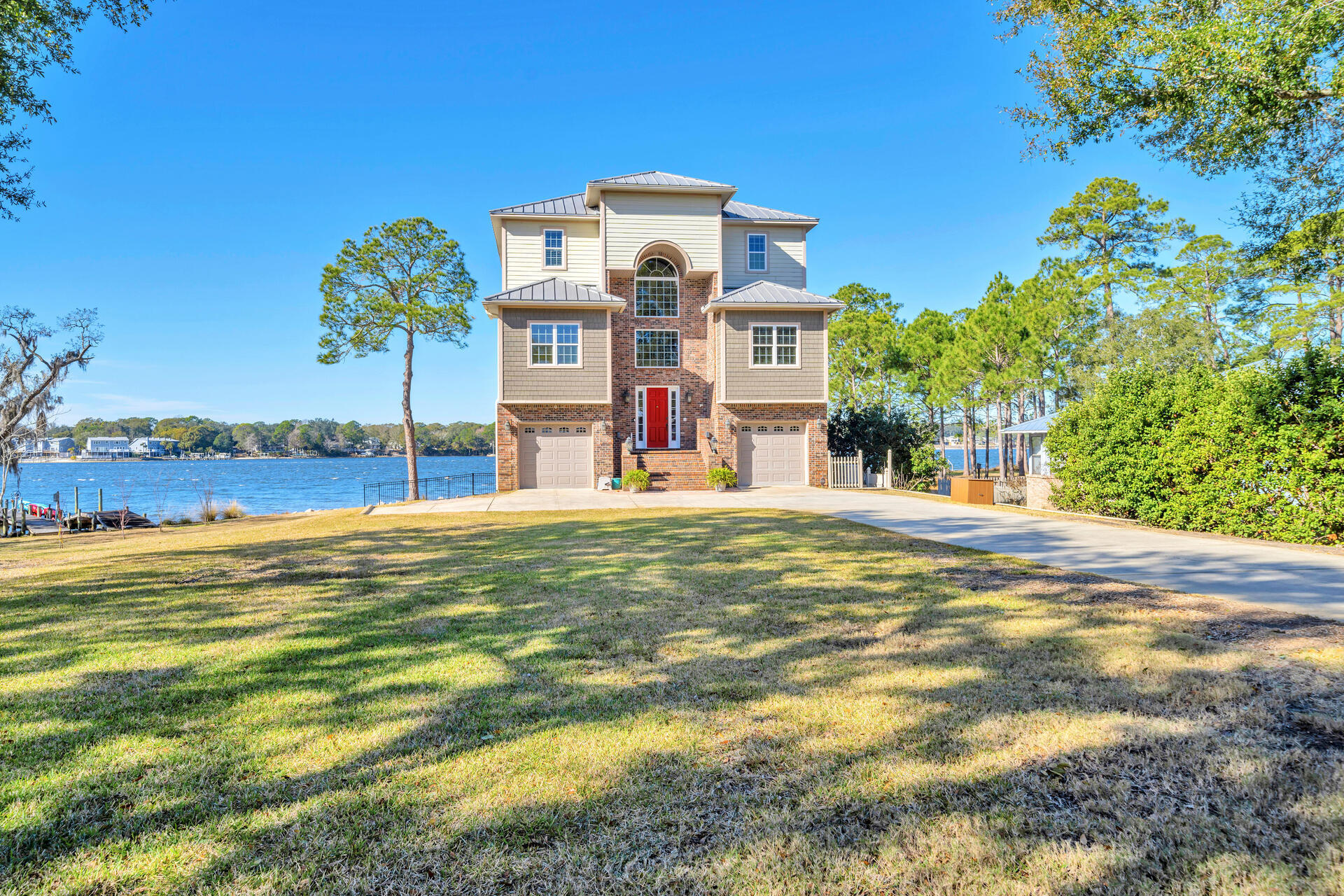 Enjoy peaceful mornings and endless sunsets from absolutely anywhere on this property - not to mention a front row seat to the 4th of July fireworks or just a 20 minute boat ride to Destin! It is evident no detail was overlooked when this custom built home was brought to life. From the deep water dock with flow-through decking and covered boat lift to the screened porch, elevator, two balconies, chef's kitchen and third floor executive primary suite...you will be so thankful you didn't miss out on the opportunity to make this YOUR home! There are so many amazing upgrades included with this property. An elevator, full house generator, well-fed sprinkler system, outdoor shower, 2 HVAC's, 2 tankless water heaters, central vacuum, intercom and speaker system, custom kitchen cabinets,
