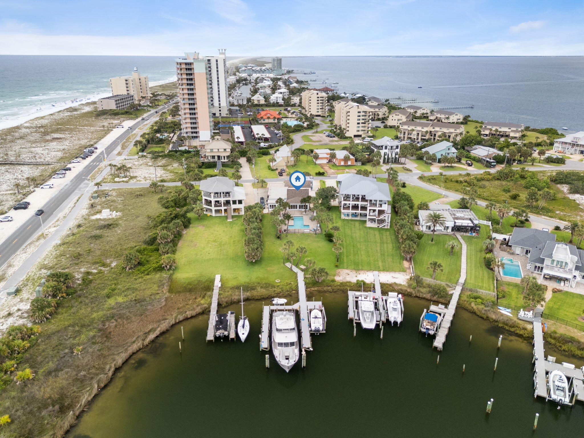 Paradise on Little Sabine Bay / DEEP WATER (11ft+) dock. This private residence features resort lifestyle living, in a coastal contemporary cottage. The private boat dock is the envy of all sport fishing and yacht enthusiast. The stellar location has exceptional appeal because of its short two minute stroll to the Gulf of America's beaches for surfing, hydrofoiling, rod fishing and shells. This original Villa Sabine property was designed to withstand hurricanes and storm surges at ground level. There are impact windows and exquisite impact storm rated triple sliders. The salt water gunite swimming pool is shaped like a T for aquatic gatherings, lap swimming and family play. Do you have an RV? There is plenty of room to park it and load out or in. Inside, you will find a spacious family room with a soaring atrium white oak custom wood ceiling. There is surround sound and LED soft glow lighting. The kitchen is professionally designed in rich walnut and is a cooks delight. Each bedroom has its own upscale bathroom with granite, custom lighting and designer sinks. All bedrooms have ample closets and storage. The open floor plan is split and the primary bedroom suite has an artisan ceiling and waterfront views of the bay and dock.The spacious master suite is 18x24 and features a triple size walk in closet complete with custom shelving and rods. The master bath has spa tub by Bain and a separate shower. There is a lifestyle gym.The extended Florida room off the living room currently has a queen size bed and is a southern sleeping porch. The home is professionally landscaped with palms and outside lighting.The custom garage features an industrial south side garage door with storage for cars, golf carts, fishing rods, tackle, beach toys, refrigeration and storage.There is a roof top crows nest to view the gulf island sunsets and the Blue Angels Air Shows. This property has had an extensive update with a new dock harboring a 67 foot yacht, Boston Whaler & water toys.