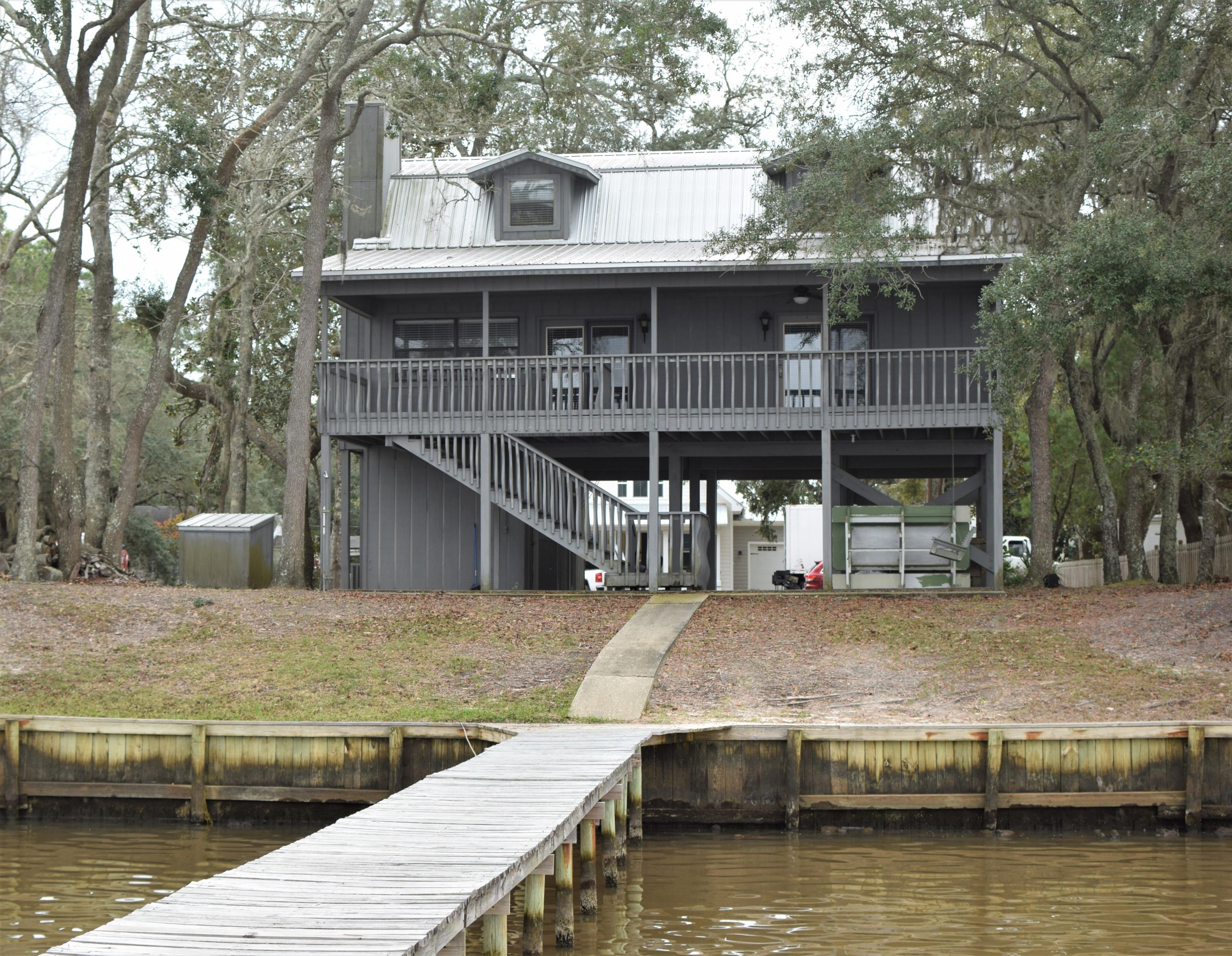 This bay front haven welcomes you with expansive views of the Choctawhatchee Bay. The elevated home's ground floor offers a covered parking space, a picturesque bay-front swing for two, and two secure outdoor storage rooms; one that could also double as added space to entertain. On this home's second and main floor, you enter to an open living area with wood floors, a cozy brick fireplace and expansive windows offering views of the bay. This open concept floor plan opens to the kitchen with tile backsplash, granite countertops, and Frigidaire stainless steel appliances. The industrial chandelier in the dining area of this bay house is the perfect finishing touch. Also on the second floor of this home are two large bedrooms, one with double doors overlooking the bay, a laundry closet, and a full bath. This cozy cottage's interior solid wood paneling and full waincoting throughout is sure to have you feeling right at home. On the 3rd floor, there are two large masters, both with a relaxing window nook meant for enjoying the latest book and views of the bay, a full bath and two large linen closets. Call The Beach Group to schedule a showing of this bay front home today!