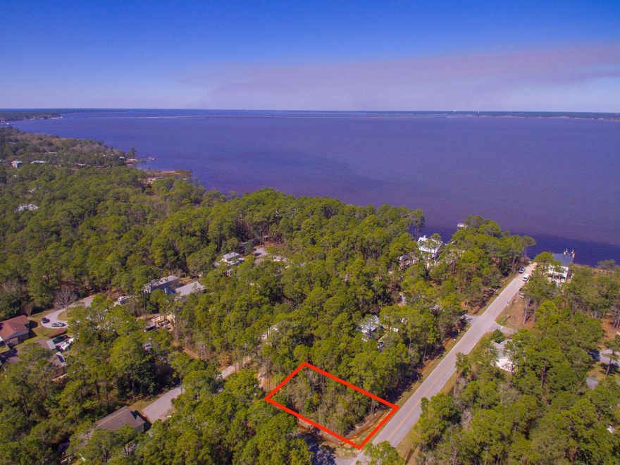 Beautiful wooded corner lot with bay view potential! Lot is in the preferable Flood Zone X (No flood insurance required) This quiet neighborhood offers seclusion and close proximity to the bustling 30A. The lot has great flexibility as it can be accessed from either Cabbage Rose or Summer Breeze. It features County paved roads, no HOA fees, and a boat launch at the end of the street contribute to the desirability of this lot plus it is less than an hour drive to the international airport in Panama City.