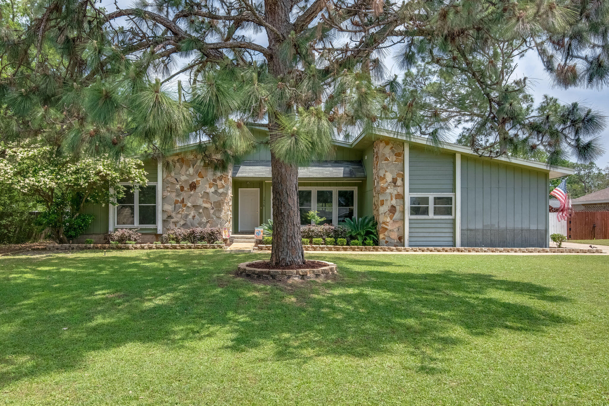 Welcome home to this adorable 3 bedroom 2 bathroom home in Holley by the Sea. Home features a side entry garage with a nice long driveway & a 2nd unpaved driveway on the other side of the home. Recently updated landscaping & pavers. As you enter in the front door you have a nice entry way that opens up to a bright living space with high vaulted ceilings, tiled floors, & wood burning fireplace. From the living room you have a nice dining area that leads into the kitchen features stainless steel appliances, & white painted wood cabinets. Home has fresh paint throughout. Newer windows and carpet in bedrooms. Sliding glass doors to the screened porch perfect to enjoy the Florida lifestyle with a large fully fenced backyard perfect for entertaining. Fence is new except across the back
