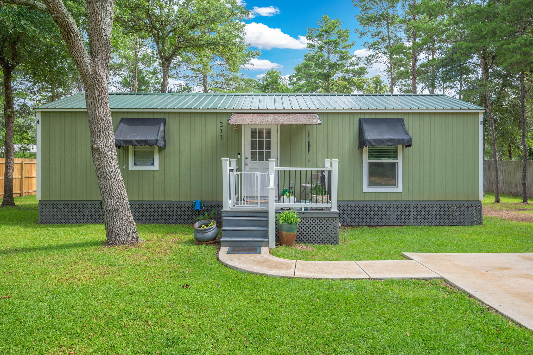Small but mighty, this adorable 2 bedroom, 1 bathroom cottage is packed with personality and designed with serious attention to detail. Sitting pretty on a .23 of an acre fully sodded lot, this gem is move-in ready and waiting for someone who appreciates quality, comfort, and a bit of flair! Step inside to find vinyl plank flooring throughout, stainless steel appliances, and a tankless electric hot water heater. Enjoy central A/C & heat to keep you comfy all year long. Yes, the washer and dryer are included, because laundry day shouldn't be a chore. The covered front porch is perfect for sipping sweet tea, and the sliding glass door opens to a back porch ready for grillin' and chillin'. A double car concrete parking pad and walkway make coming home a breeze, while the Ring doorbell adds a smart touch of security. Need storage or a hobby space? You'll love the 12x24 powered yard building out back, ideal for your tools, toys, or crafting kingdom. The partially fenced yard offers space for pets or privacy, and the whole package is tied up with charm and craftsmanship. Whether you're starting out, downsizing, or looking for a weekend retreat...this cottage is cute, clever, and completely move-in ready.