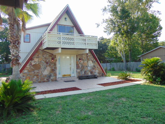 Unique A-Framed Destin home that sits on two lots. The living room has wood flooring and a fireplace. The kitchen has beautiful oak cabinets and 18 in. tile. The laundry room, and 1/2 bath conveniently located off of the kitchen. The master bathroom has a large walk-in shower; Master bedroom downstairs has new wood flooring; walk out the sliding glass door that leads to the large screened porch and overlook a large deck and 6 foot deep in-ground fish pond. Upstairs is perfect for guests; 2 bedrooms and bath plus wet bar and loft!! There is a three car garage and a workshop. There is a separate one car garage that can not be utilized. Walking distance to Destin Elementary, three blocks to boat ramp and bay.Pet friendly. No smoking.