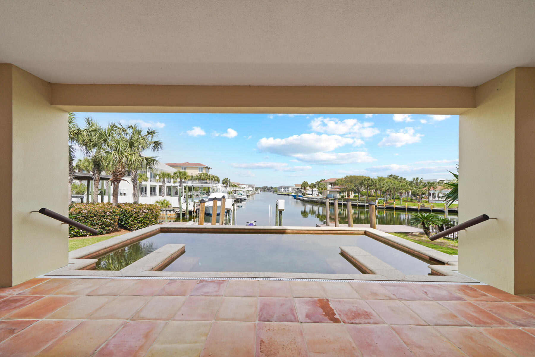 Prime waterfront with convenient access to the beach. This location has amazing gulf and harbor views unlike any on Holiday Isle.  Inspired by the architecture in Mexico and Costa Rica, this very custom home show cases authentic Spanish tiles adorning the main living spaces, each tile a unique piece of art. The concrete construction adds to peace of mind against the elements. The open-air floor plan effortlessly transitions between indoor and outdoor living space. Perfect for entertaining with ample parking and bedrooms are all ensuite. The upstairs living area can be accessed by stairs or an elevator.  The Primary bedroom on the top floor has a large private balcony as well as a large walk in closet and a separate office space.