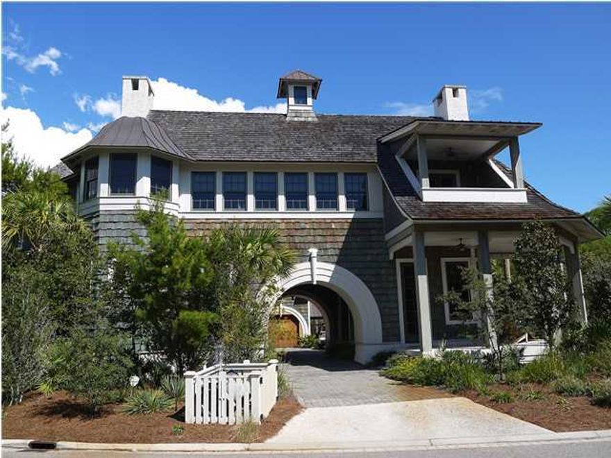 Savoie Architects, P.A.'s most exquisite home design to date. Ideally situated on one of the largest corner lots available in Watersound, this unique home draws immediate attention with its arched portico entrance leading into the courtyard with a custom designed infinity edge pool and spa. The first floor of the main house has 3 bedrooms, 3.5 baths, and a separate parlor room with wet bar for intimate gatherings. Spectacular 12 foot ceilings and 10 foot exterior doors speak to the unsurpassed grandness of this home. Access the main living area located on the second floor via elegant staircases rising both from the main house and the parlor (Home also includes an elevator shaft). The second floor has towering ceilings with exposed beams and an open floor plan allowing for the