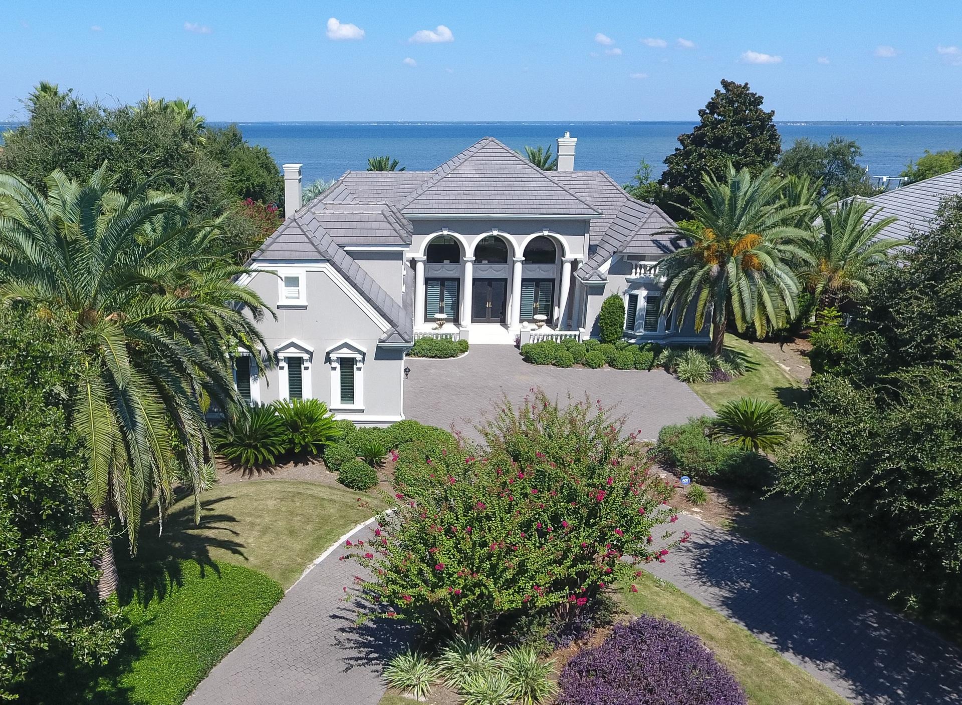 Stunning custom bay front home that is a must see! Great curb appeal with a circular brick paver drive and impressive entrance opening to a grand living and dining area offering the first of many spectacular bay views. Carefully designed floor plan, perfect for family and entertaining, with formal and casual living areas and the master suite all opening onto a large screened lanai with covered outdoor living area, sparkling pool and spa. The gorgeous gourmet kitchen will please the fussiest cook, with Thermadore gas cook top and double ovens, SubZero refrigerator, Bosch dishwasher, tons of custom cabinetry and gleaming granite counters. Roomy breakfast area has mitered glass by window overlooking the pool and bay. There's also a butler's pantry/wet bar located in the hallway, just