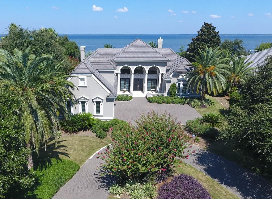 Stunning custom bay front home that is a must see! Great curb appeal with a circular brick paver drive and impressive entrance opening to a grand living and dining area offering the first of many spectacular bay views. Carefully designed floor plan, perfect for family and entertaining, with formal and casual living areas and the master suite all opening onto a large screened lanai with covered outdoor living area, sparkling pool and spa. The gorgeous gourmet kitchen will please the fussiest cook, with Thermadore gas cook top and double ovens, SubZero refrigerator, Bosch dishwasher, tons of custom cabinetry and gleaming granite counters. Roomy breakfast area has mitered glass by window overlooking the pool and bay. There's also a butler's pantry/wet bar located in the hallway, just